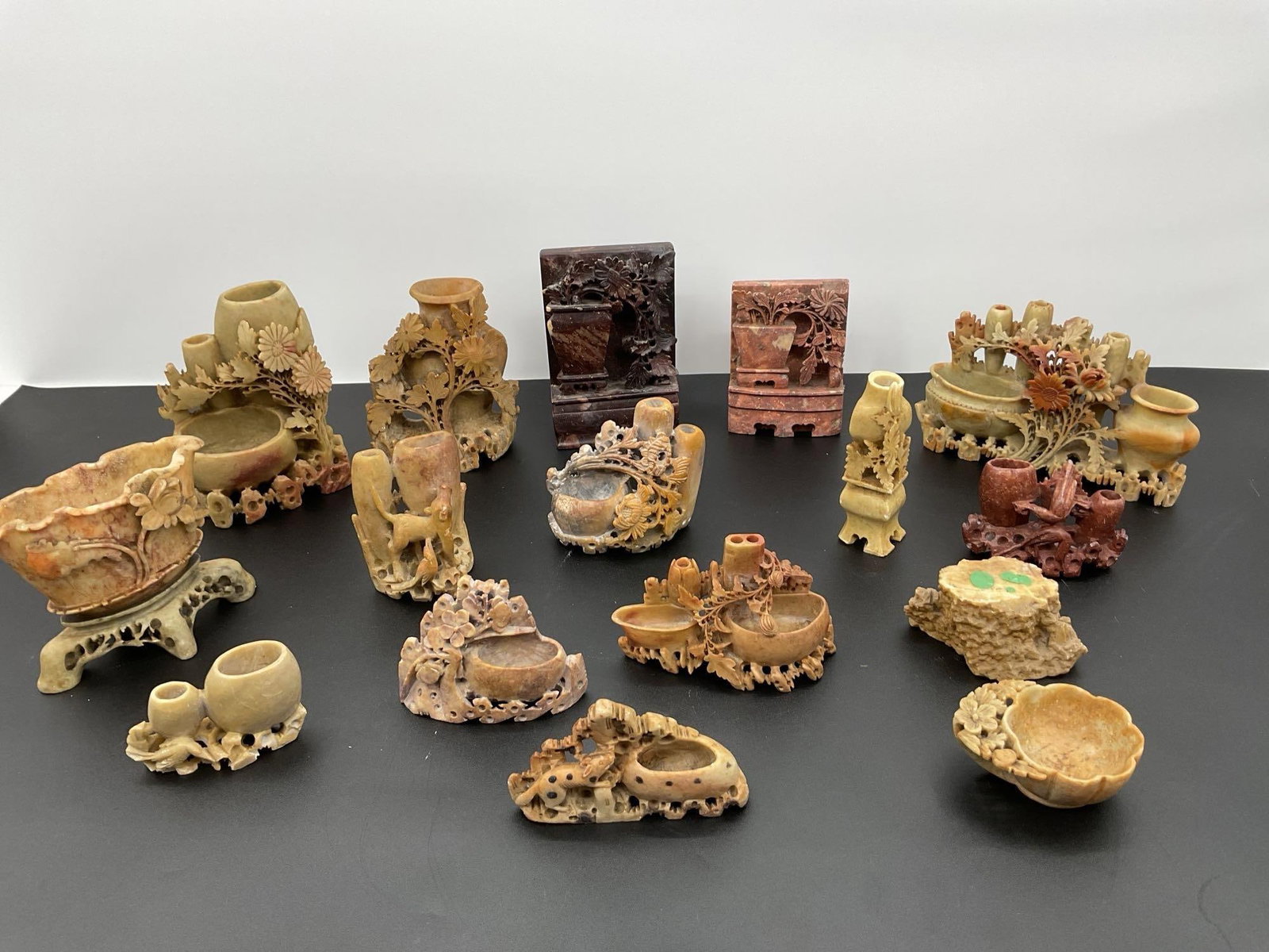 Collection of Antique Chinese Soapstone Brush Washers and Vases: This is a collection of intricately carved antique Chinese soapstone brush washers and vases, likely dating from the late Qing Dynasty (19th to early 20th century). Each piece is meticulously hand-car