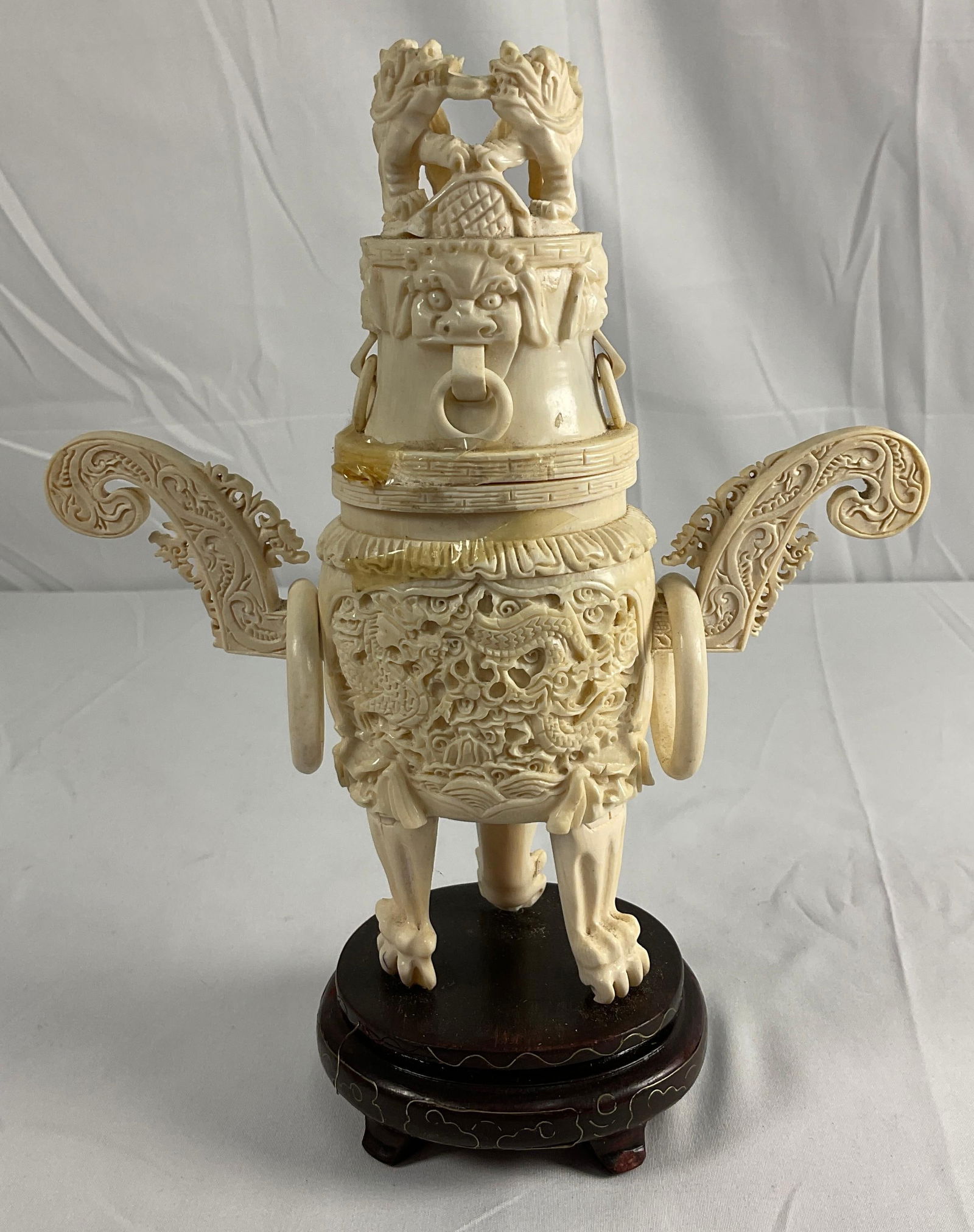 Chinese antique censer, also known as an incense burner: The censer is supported by three legs, each ending in mythical beast paws, giving it a regal and powerful stance. The body is adorned with high relief carvings of dragons, which symbolize power, stren
