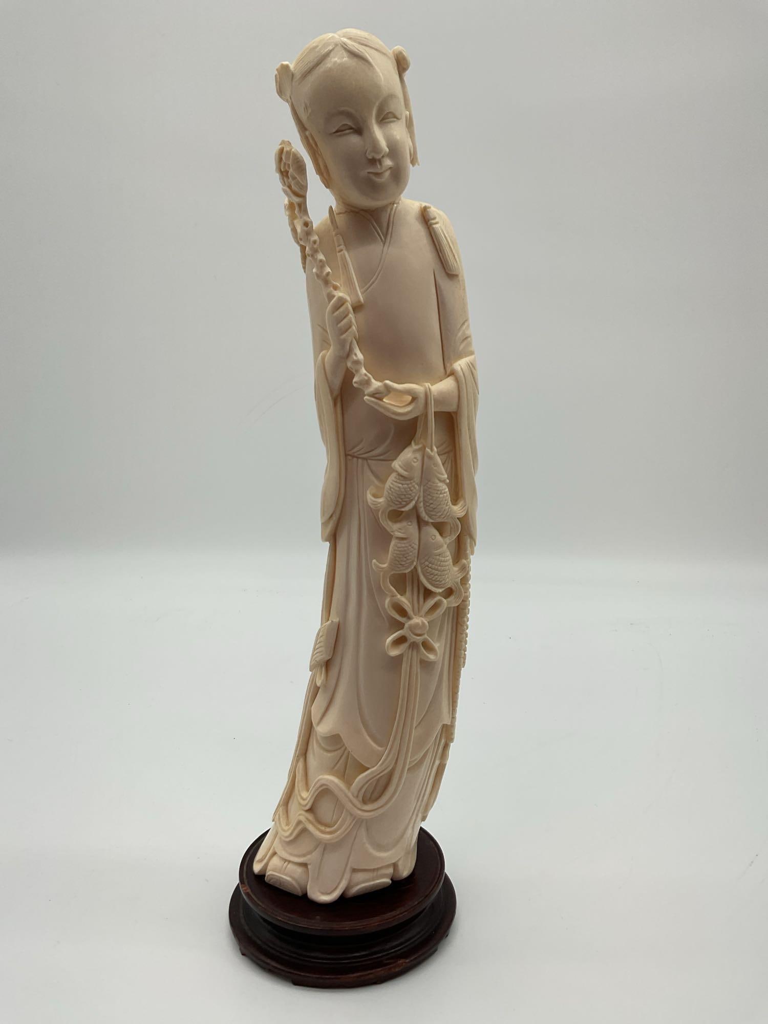 Asian Female Figure with Fish and Lotus: Finely carved figure of an Asian woman holding a lotus stem, with detailed elements including flowing robes and two fish hanging at her side. Likely intended to represent a symbol of prosperity and ha