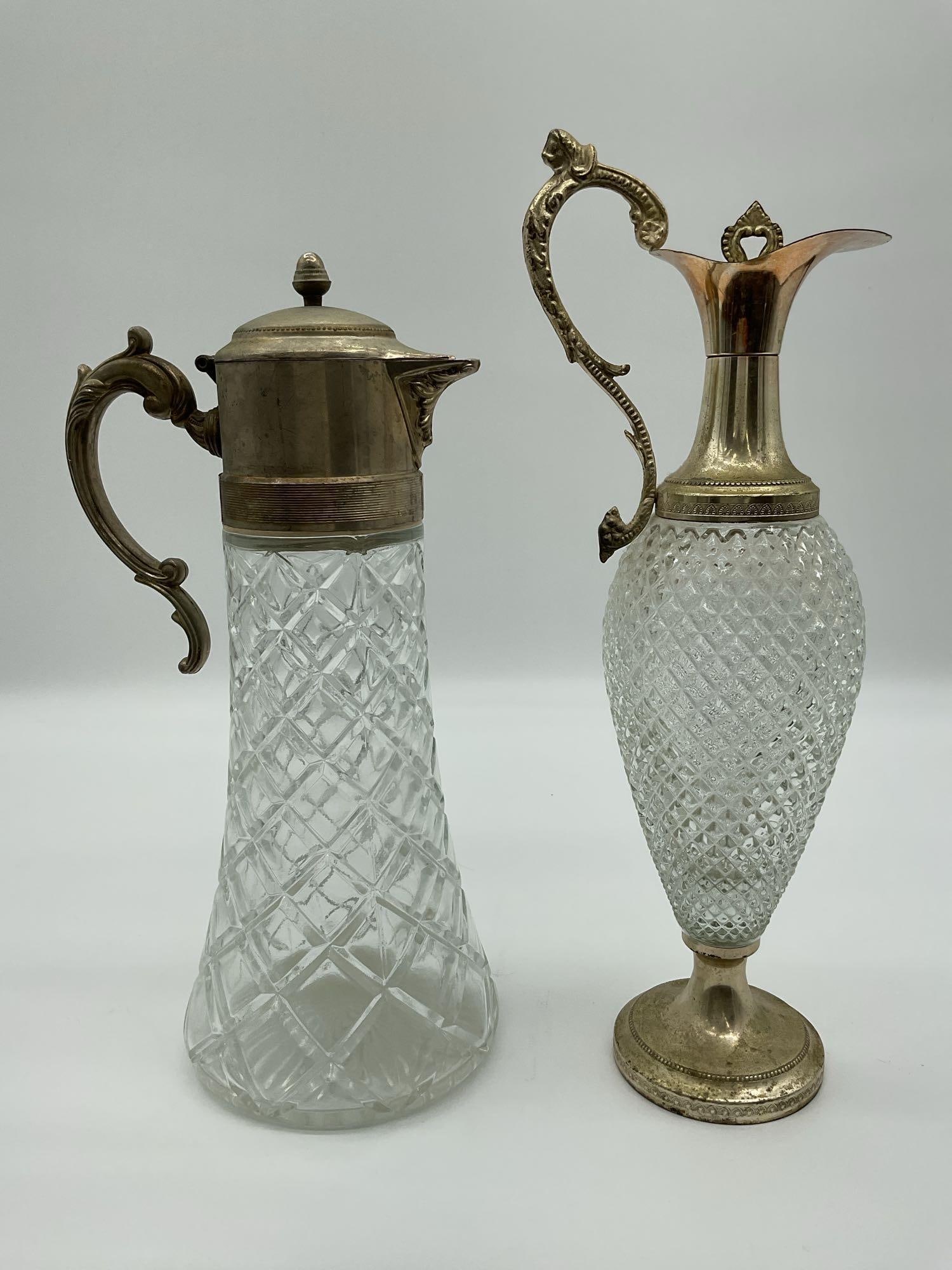 Vintage Pair of Antique Pressed Glass and Brass Ewers: Elegant pair of antique-style ewers featuring pressed glass bodies with diamond and crosshatch patterns, complemented by ornate brass mounts, handles, and spouts. One with hinged lid and classical mot