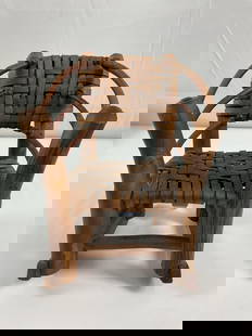 Miniature splint Rocking Chair - Box 17: This is a handcrafted miniature wooden chair featuring a woven rattan or reed seat and backrest. The curved armrests and sturdy wooden frame give it a rustic folk art aesthetic. The craftsmanship sugg