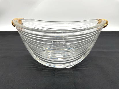 Ribbed Glass Bowl with Gold-Tone Dolphin Handles: Clear ribbed glass serving bowl with a rounded form, accented by two sculpted gold-tone dolphin handles affixed at the rim. Dimensions: H5in L10in W8in Medium: Pressed glass with metal accents