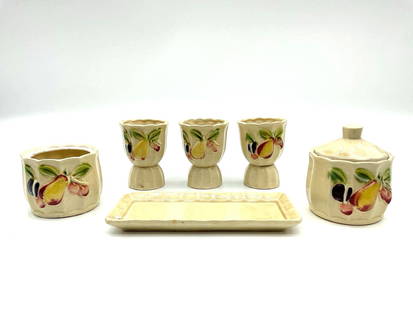 Mid-Century Japanese Hand-Painted Ceramic Condiment Set: Group of seven hand-painted ceramic kitchen items made in Japan, featuring a fruit motif. The set includes three egg cups, two lidded jars, an open jar, and a small rectangular tray. Each piece has a