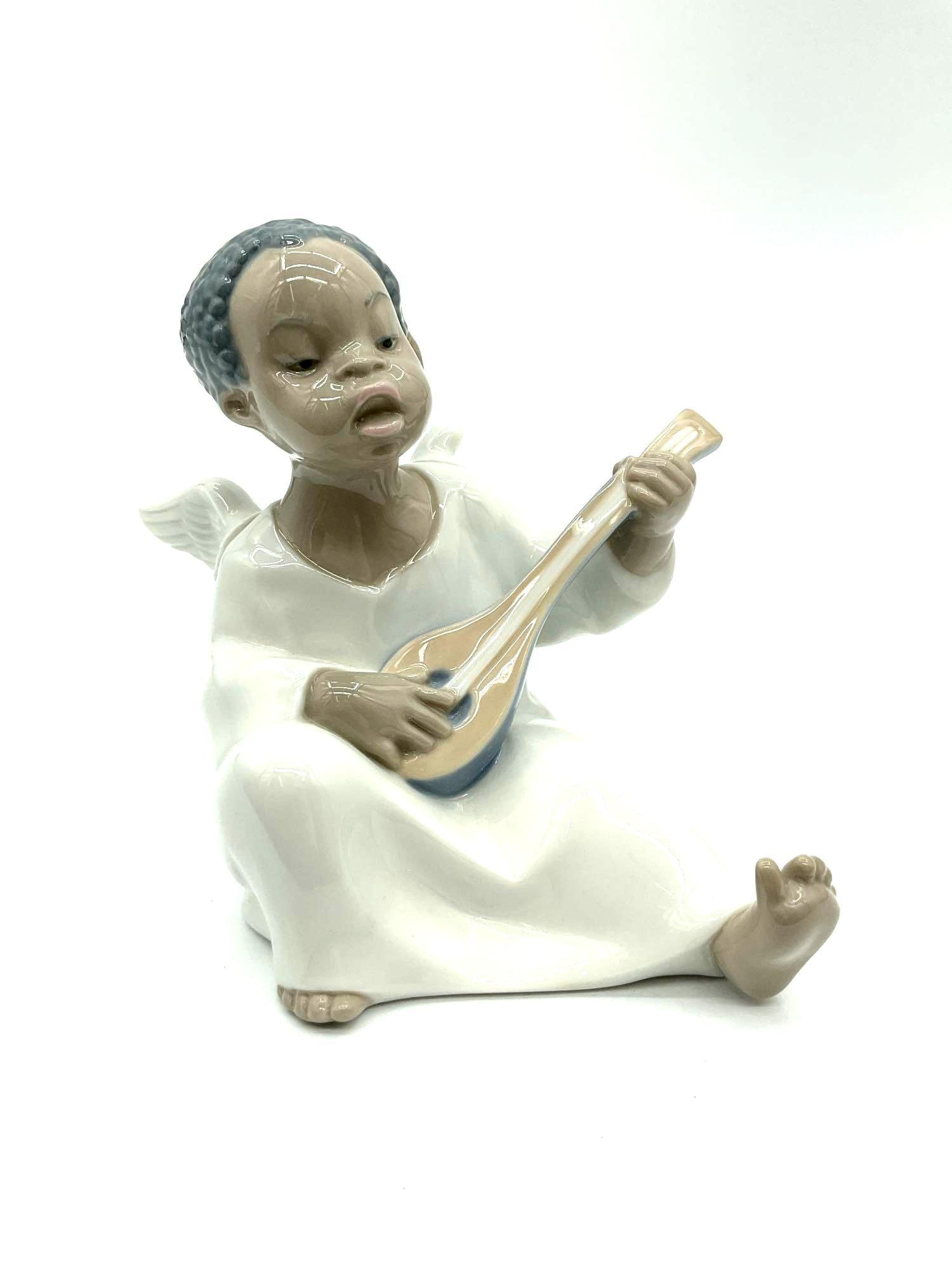 Lladro Angel with Mandolin Figurine #4537: Porcelain figurine of a kneeling angel playing a mandolin, finished in soft pastel glazes. Marked Lladro, made in Spain, model number 4537. Dimensions: H5in L5in W4in Medium: Glazed porcelain