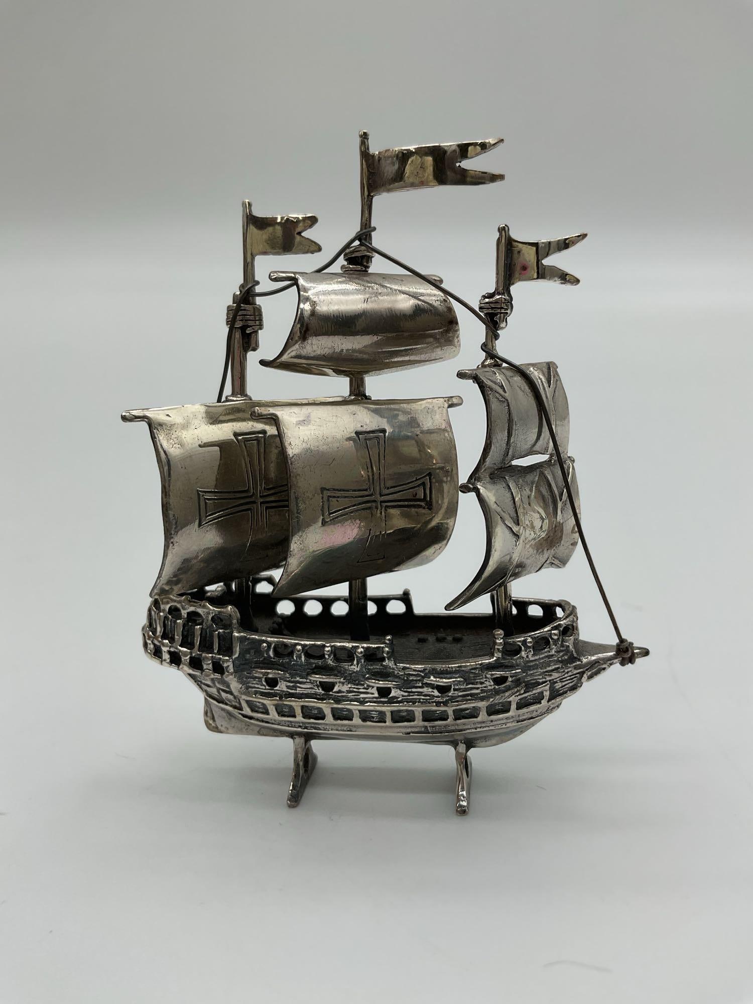 Vintage Sterling Silver Galleon Ship Figurine: This finely detailed miniature figurine depicts a classic galleon ship, complete with waving flags, rigging, and embossed sails featuring a cross motif reminiscent of early European exploration vessel