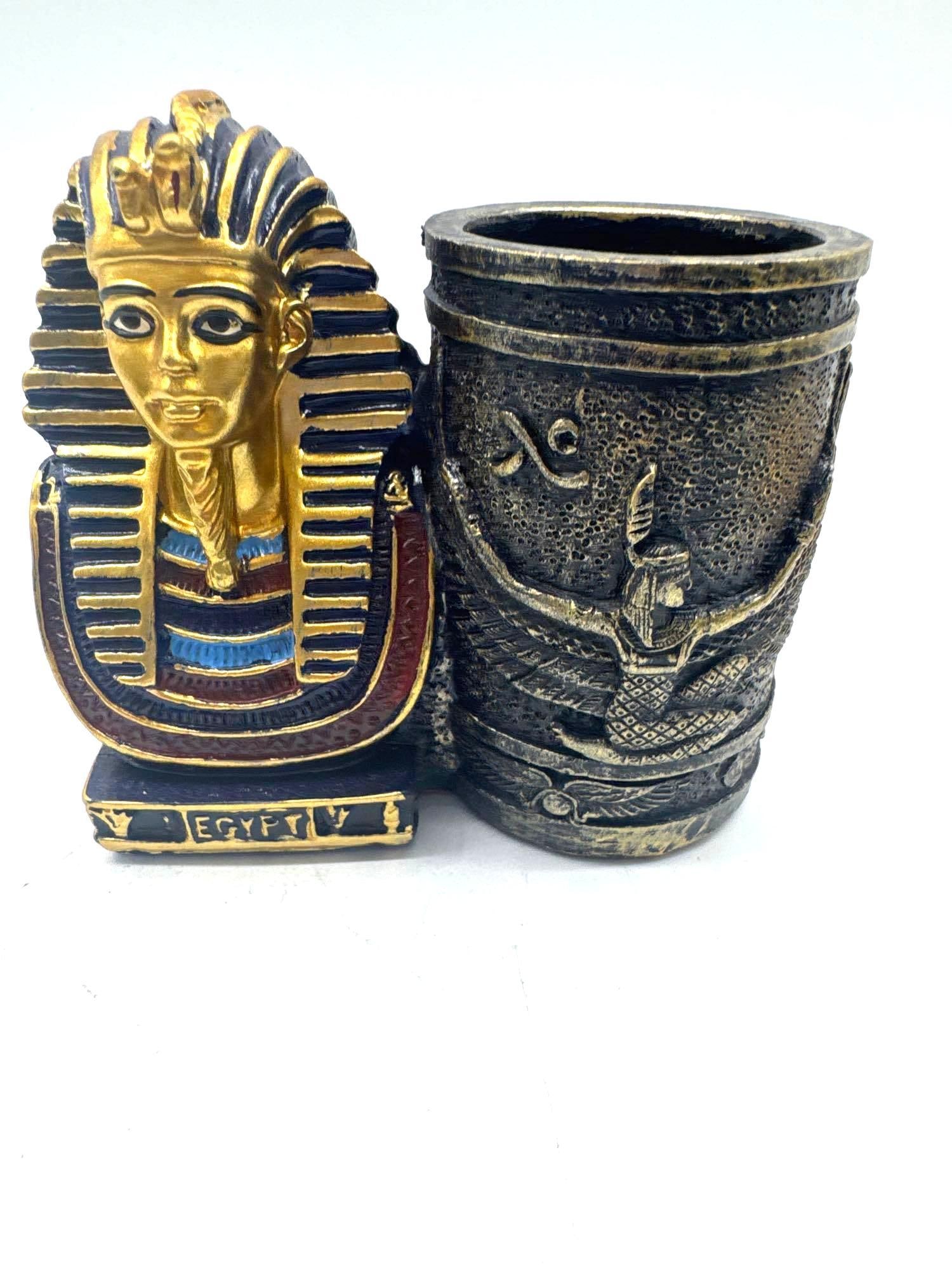 Set of 3 Egyptian Pharaoh and Goddess Pens with Tutankhamun Pen Holder: Colorful trio of souvenir pens topped with miniature pharaohs and Egyptian deities, including figures resembling Nefertiti, Horus, and Tutankhamun. Comes with a decorative resin pen holder featuring a