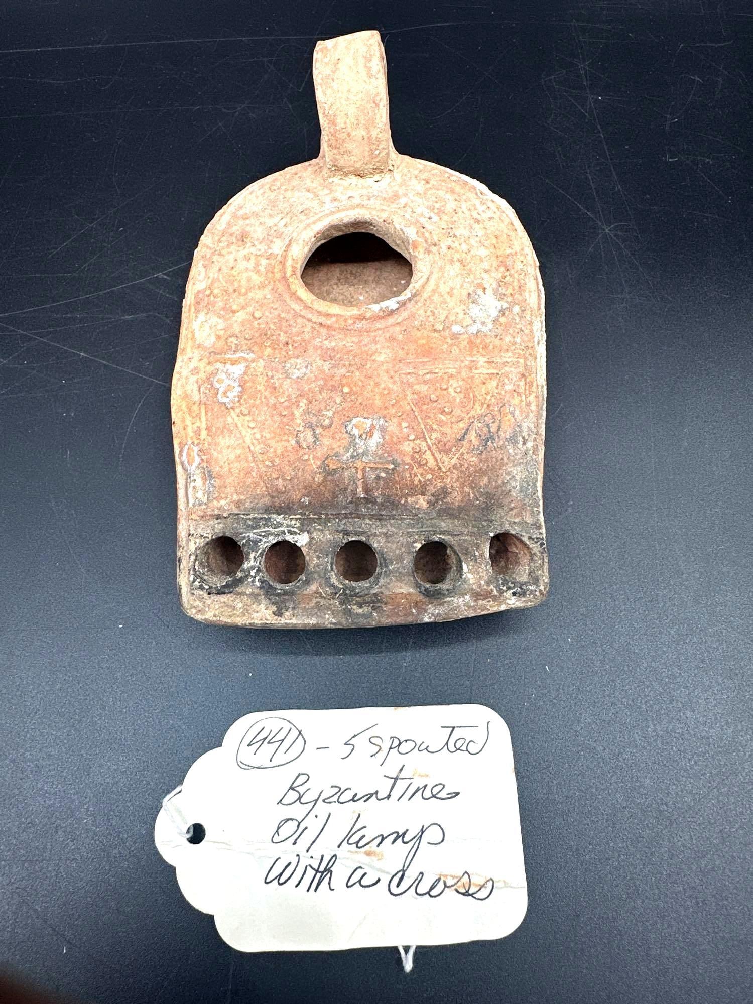 Byzantine Five-Spouted Oil Lamp with Cross Motif - Box 2 - 441: Description: Terracotta oil lamp from the Byzantine era, featuring five spouts aligned along the flat nozzle edge. The surface bears Christian iconography, including a cross, reflecting its religious 