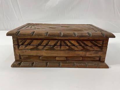 Antique Hand-Carved Wooden Trinket or Jewelry Box: This is a hand-carved wooden trinket or jewelry box, featuring geometric and stylized floral patterns on the lid and sides. The zigzag border and crosshatch corner carvings suggest a folk or indigenou