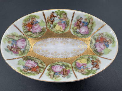 Romantic Courting Scene Compote Dish with Gilt Trim: This small porcelain pedestal compote dish features a repeated pattern of 18th-century-style courting couples in lush outdoor settings, each framed in a panel-like segment. The center of the bowl is r
