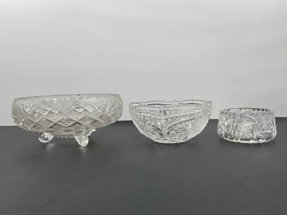 Assorted Vintage Cut Glass and Pressed Crystal Bowls: This collection includes three decorative glass bowls. The largest appears to be a round ashtray or centerpiece bowl with a diamond and starburst pattern. The middle bowl features pressed floral motif