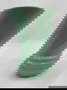 McCoy Green Glazed Vase: A vintage vase featuring a flared cylindrical form with a ribbed base, finished in a soft celadon green glaze. The minimalist design and glaze tone are characteristic of mid century studio pottery. Th