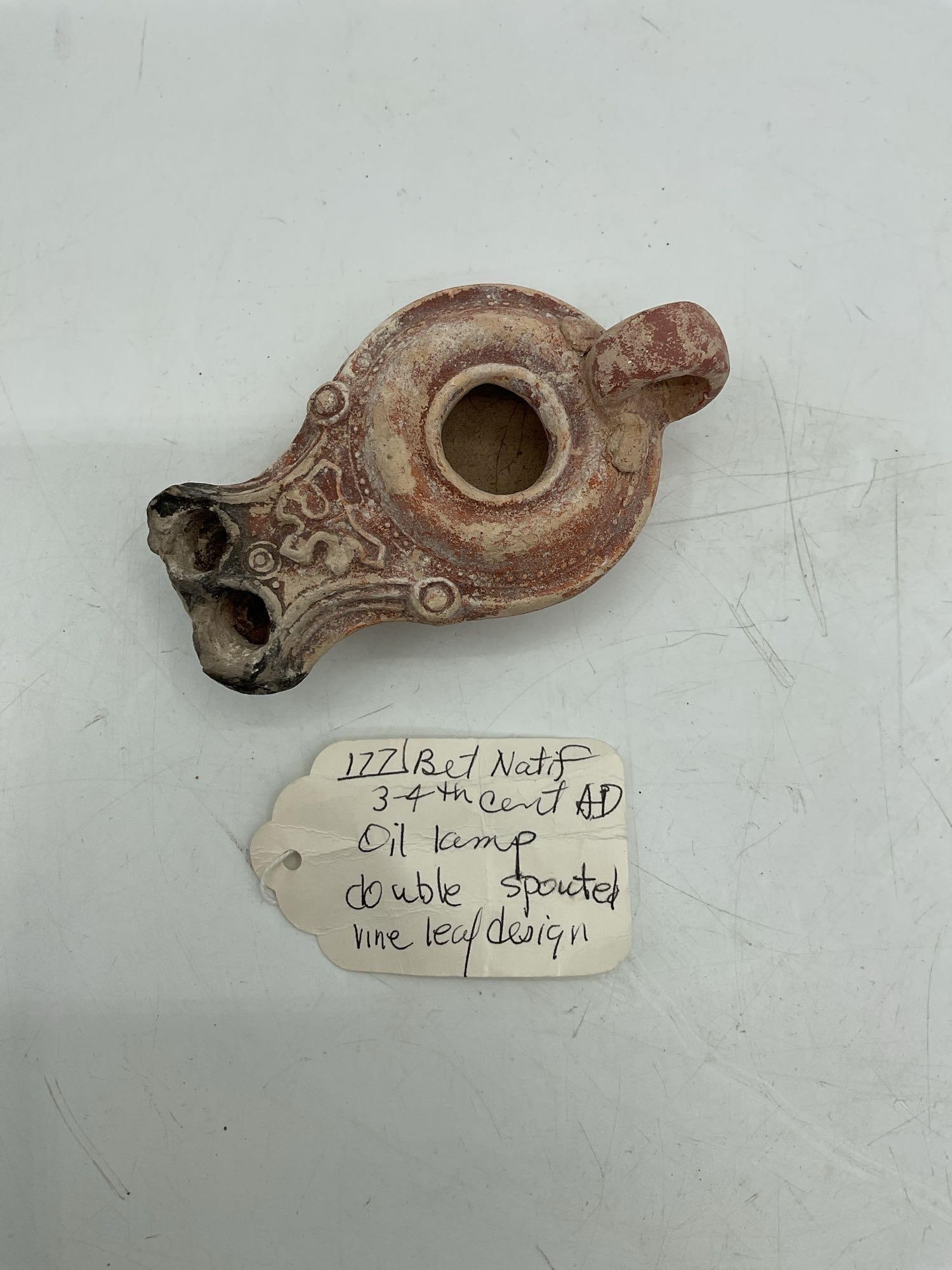 1171 Bet Natif 3-4th Cent A.D double spouted vine leaf design: A 3rd to 4th century AD oil lamp featuring a double spout and vine leaf design, originating from Bet Natif. Medium: Terracotta