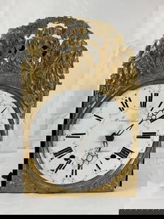 19th-Century French Comtoise Clock by Moreau Aîné: An antique French Comtoise clock with a decorative gilded brass repoussé front plate featuring a pastoral scene of elegantly dressed figures in a garden setting. The clock face is made of white ename