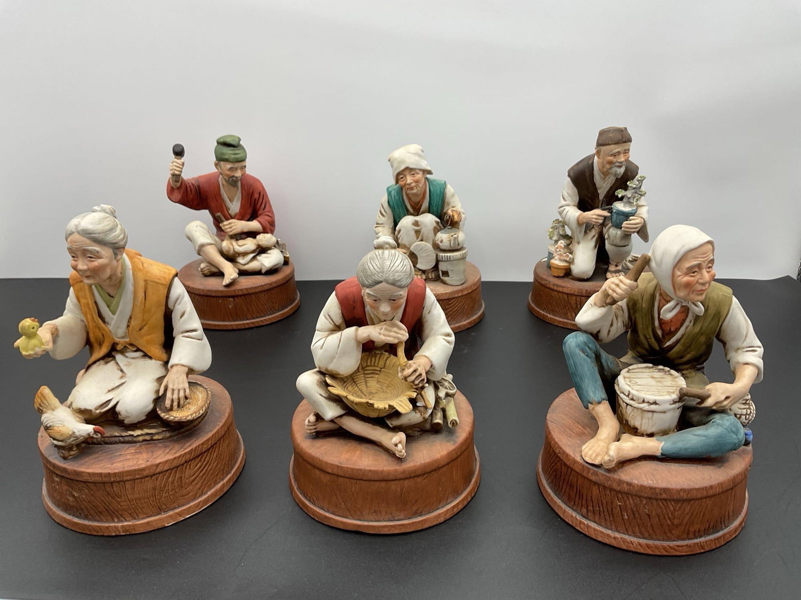 1974 Lionstone Limited Edition Liquor Decanters – Korean Folk Series - Filled: This set of sculptural porcelain liquor decanters was produced by Lionstone in 1974 as part of a limited edition line. Each decanter is styled as a detailed figure of elderly Korean villagers engaged 