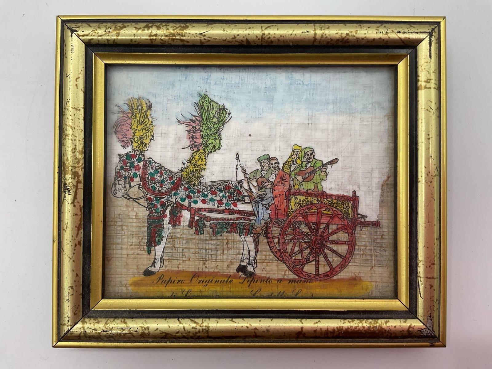 Sicilian Carriage with Musicians Hand Painted on Papyrus: A lively hand painted scene on authentic papyrus depicting a traditional Sicilian horse drawn carriage adorned with bright decorations and feathers. The cart is filled with musicians in colorful attir