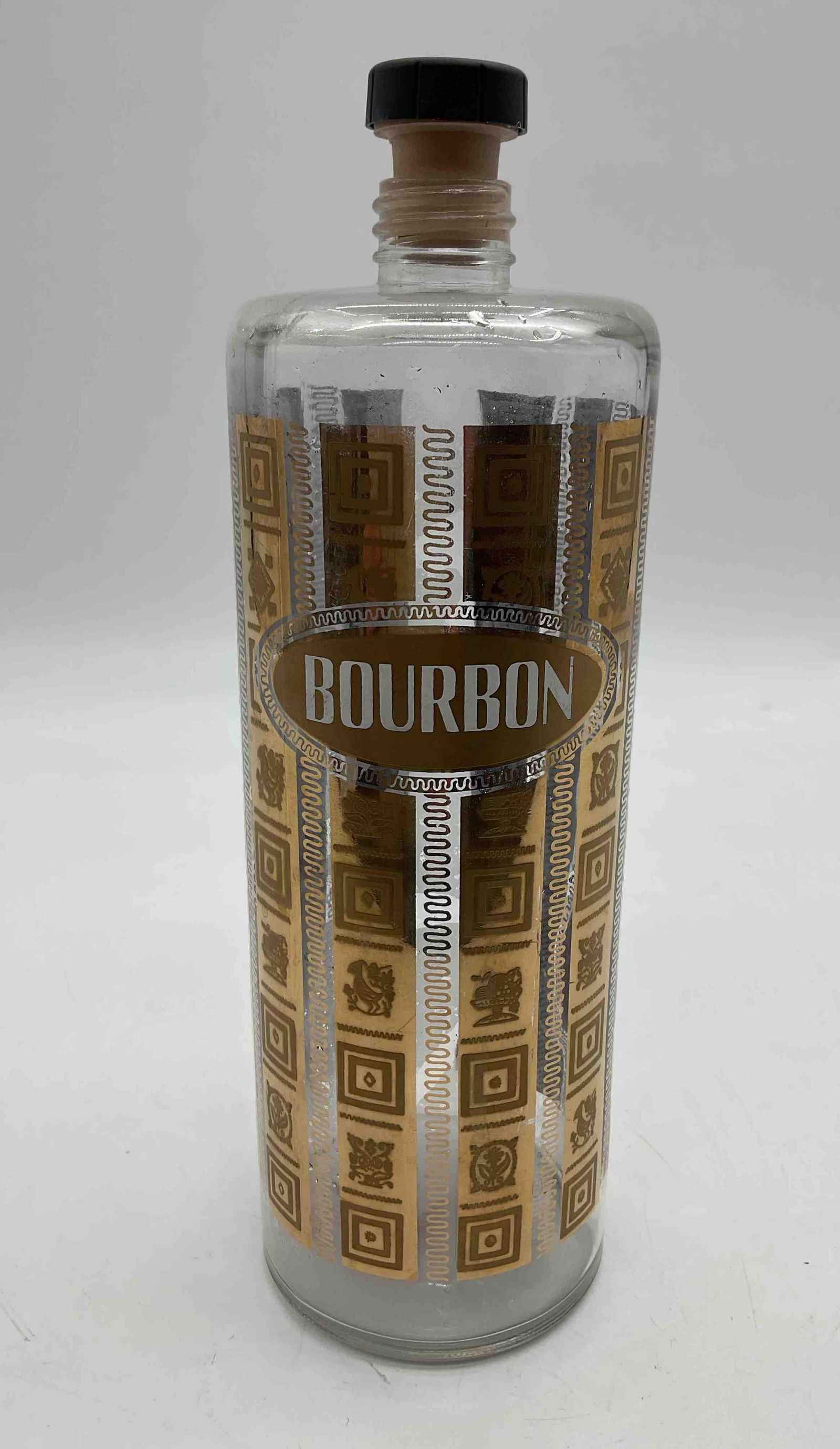 Vintage Bourbon Cork Decanter Decanter: Clear glass bourbon decanter with gold-toned label design, ideal for serving or display. Medium: Glass with printed label and stopper Dimensions: H10in Dia3in