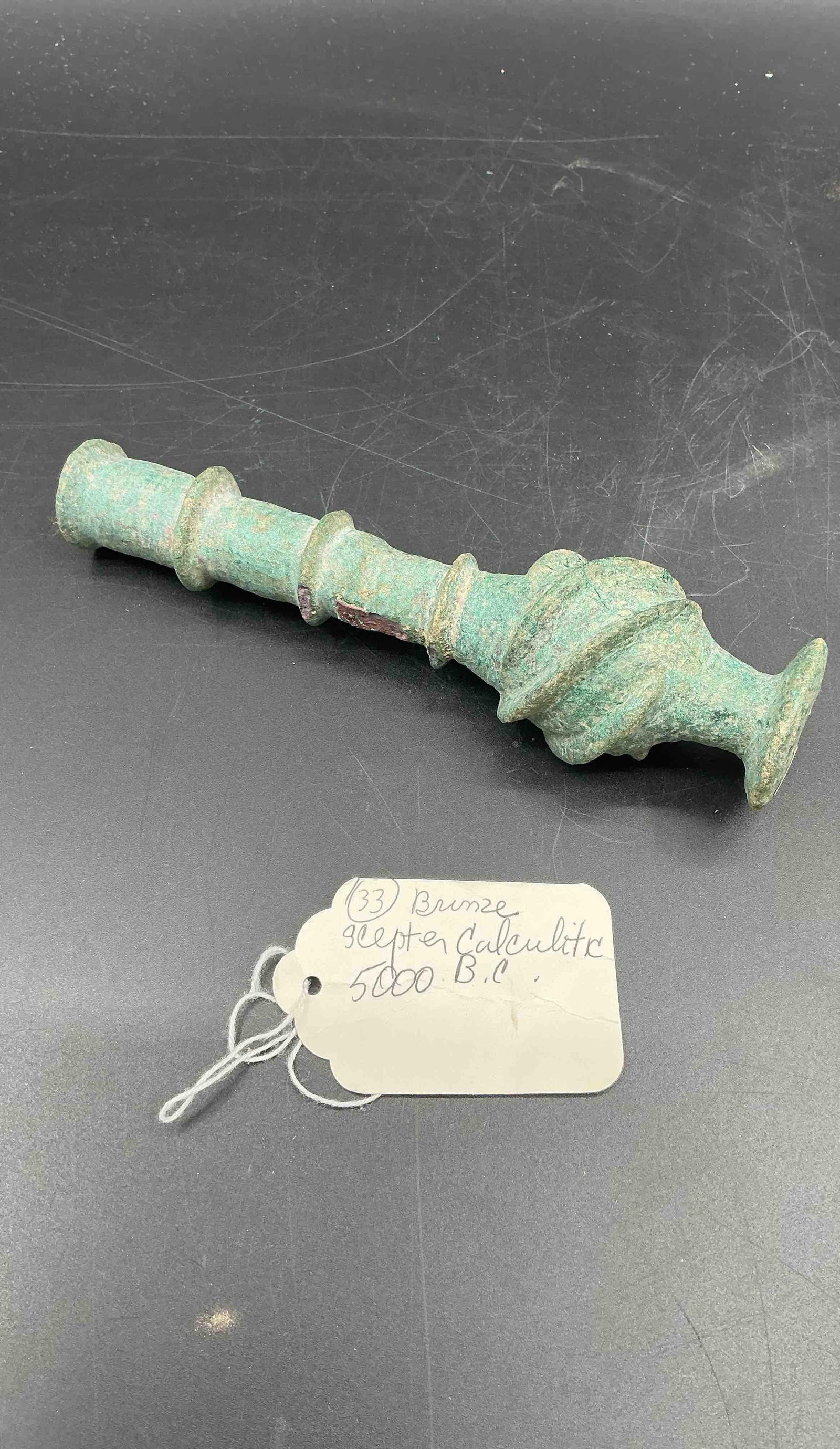 33 - Bronze Sceptee Calculitic 5000 B.C.: Ancient bronze scepter from the Calcultic period, approximately 5000 BC, featuring detailed craftsmanship and a verdigris patina. Medium: Bronze dimensions approx 7 in h x 2in diameter