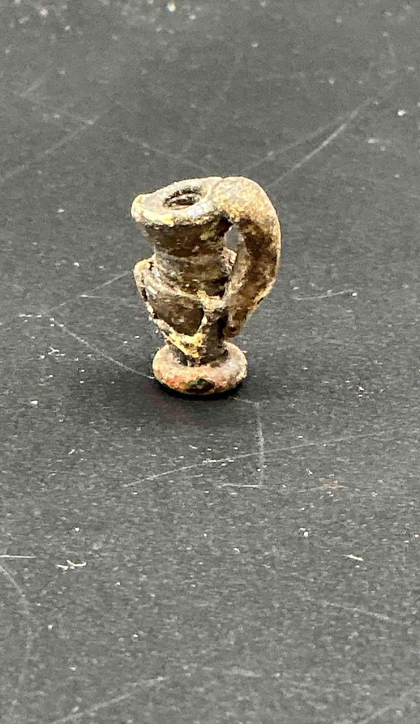 465 - Miniature Roman Bronze Amphora Pendant: A diminutive ancient Roman amphora-shaped pendant cast in bronze, likely used as a personal ornament or votive offering. Features a single loop handle and flared base, with a perforated opening at the