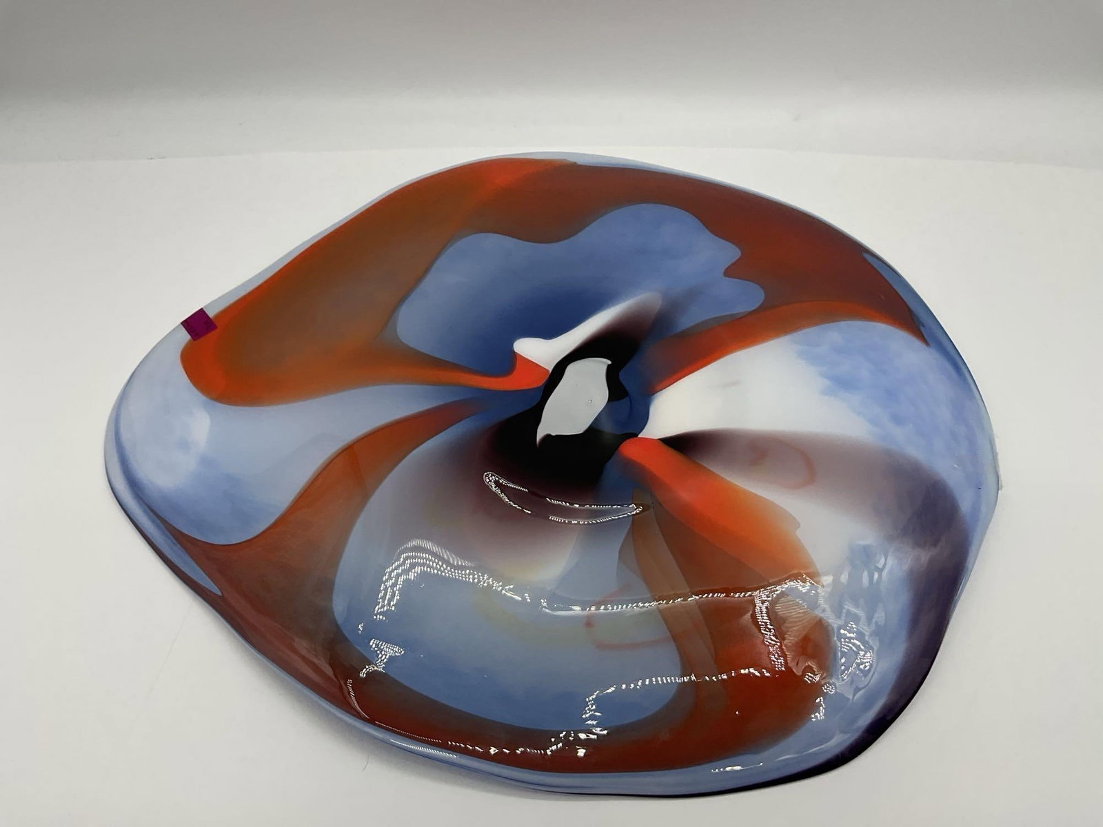 Contemporary Art Glass Bowl with Abstract Center: Large freeform art glass bowl featuring a vibrant swirl of yellow, red, and orange filament at the center, encircled by blue and white mottled patterns. Likely hand-blown, studio-made glass with stron