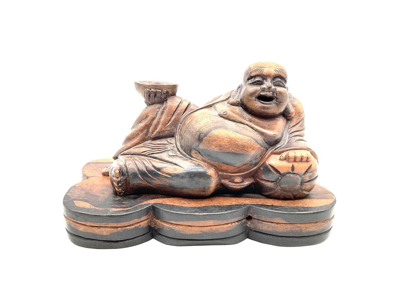 Reclining Laughing Buddha Wood Sculpture: Hand-carved wooden figure of a reclining laughing Buddha holding a gold ingot, symbolizing prosperity and contentment. Dimensions: H5in L7in W4in Medium: Carved wood
