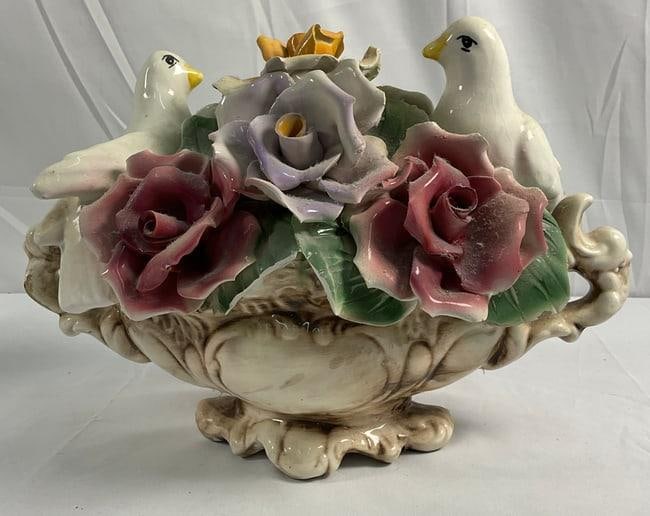 Capodimonte Porcelain Centerpiece: A stunning Italian porcelain centerpiece crafted by Capodimonte. The piece features intricate details of vibrant roses and two white doves perched elegantly among the floral arrangement. The centerpie
