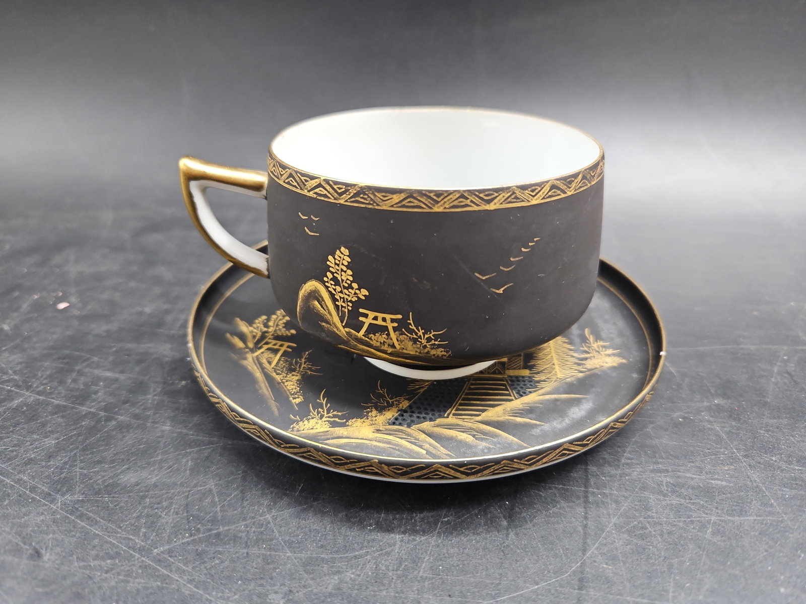 Japanese Porcelain Black & Gold Cup & Saucer: Japanese Porcelain cup & saucer, cup: H2.5in L3.25in, saucer: Dia5.25in