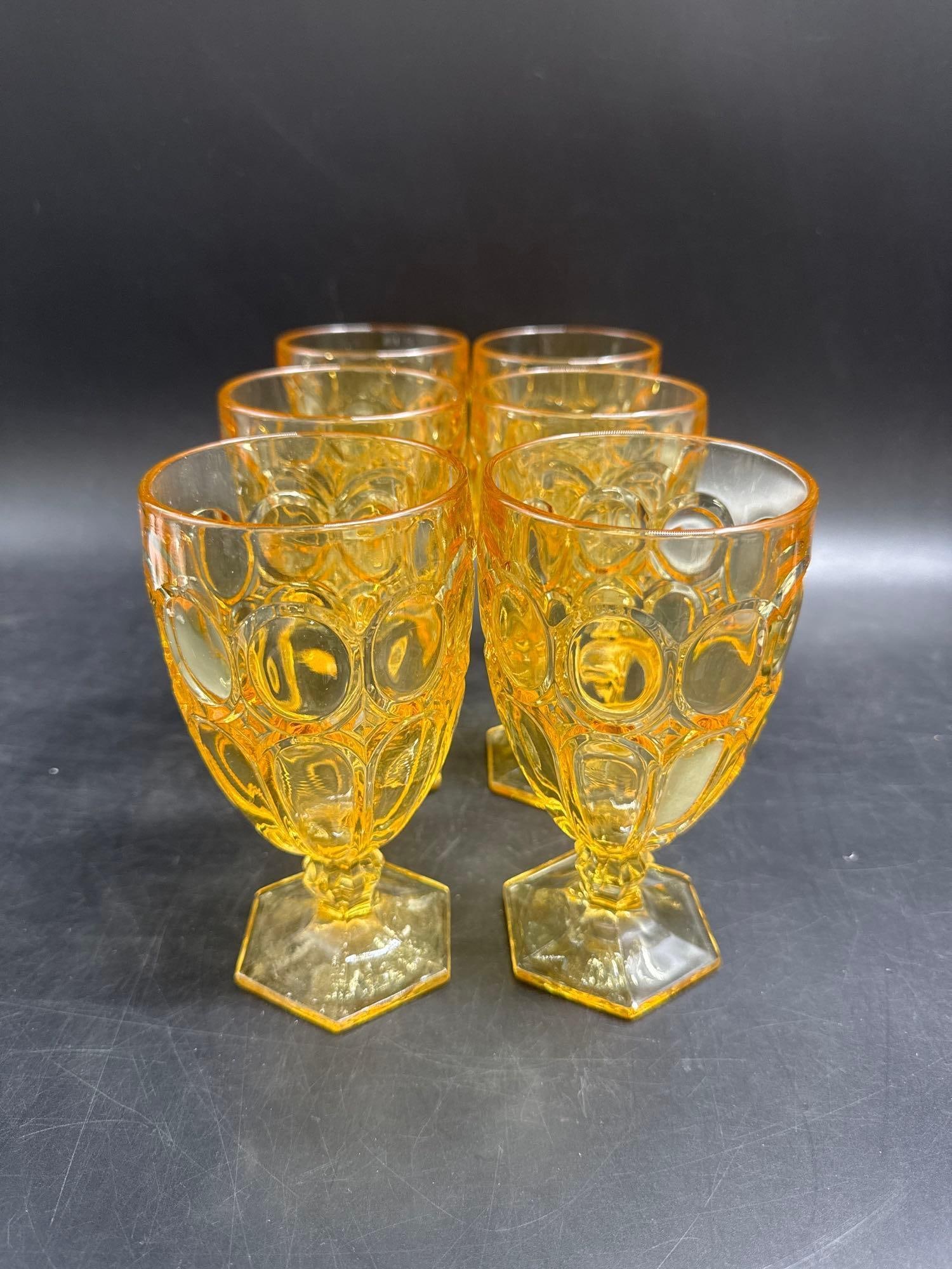 Set of 6 Vintage Amber Honeycomb Goblets: A striking set of six amber pressed glass goblets with a honeycomb (coin dot) pattern and hexagonal bases. Their warm golden tone and bold geometric design reflect mid-century style, making them both