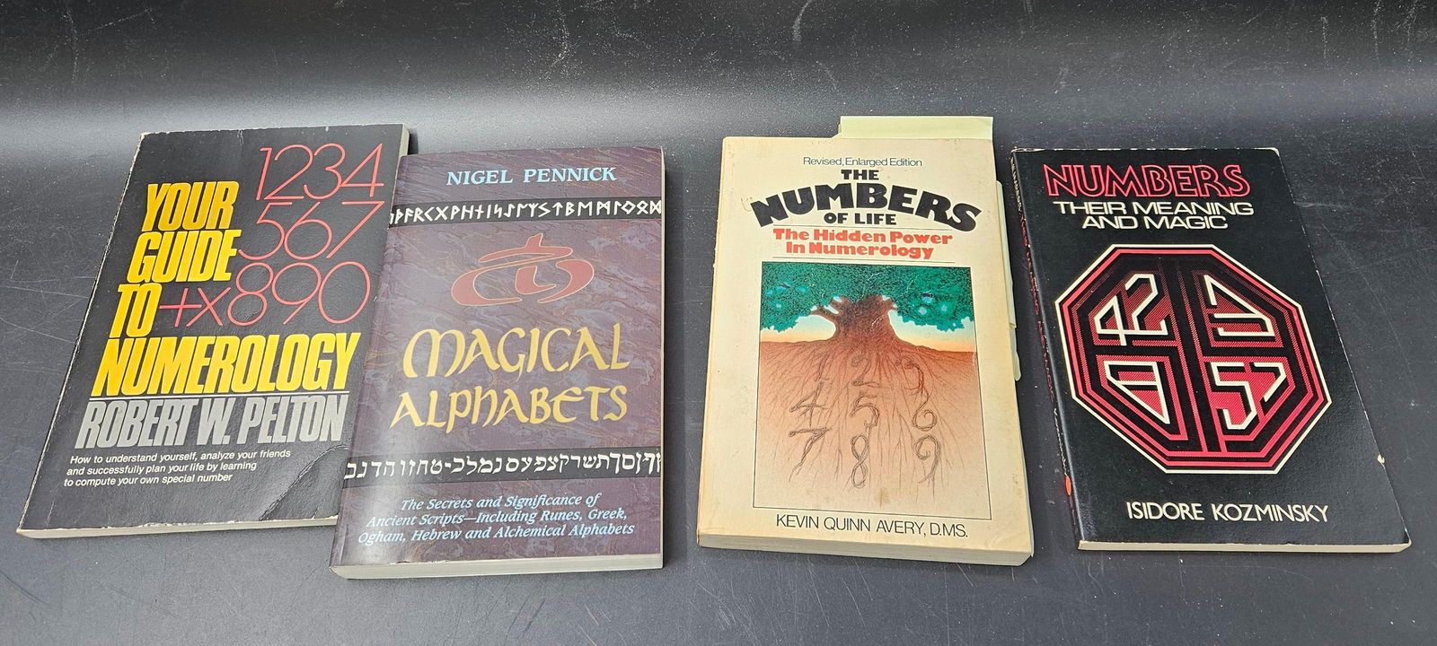 Lot of Four Numerology and Symbolic Reference Paperbacks: Collection of four vintage and modern paperbacks on numerology and symbolism including Your Guide to Numerology by Dustin W. Pynne, Magical Alphabets by Nigel Pennick, Numbers the Universal Language b
