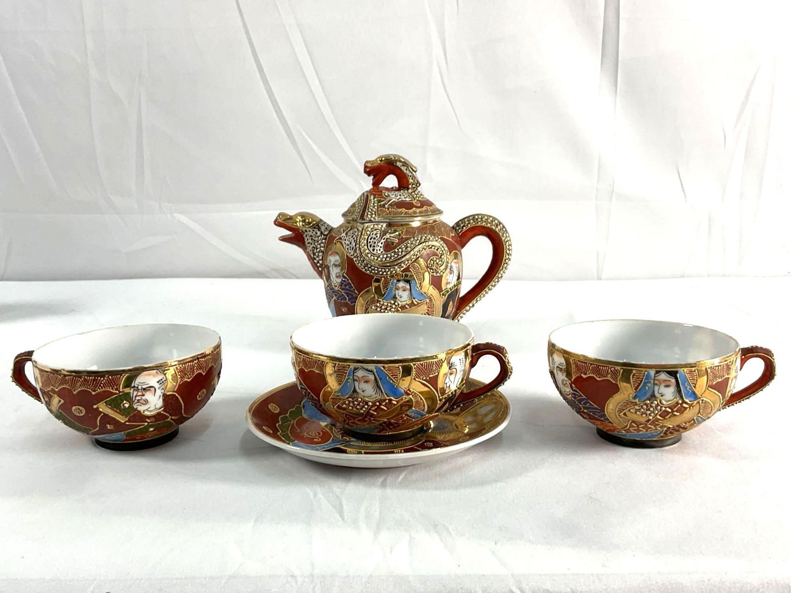 Kutani Japanese Satsuma Tea Set: 5 pc. Japanese Satsuma ware tea set, teapot: H5in L7in W5in, tea cup: H2in Dia4in, saucer: Dia6in approx