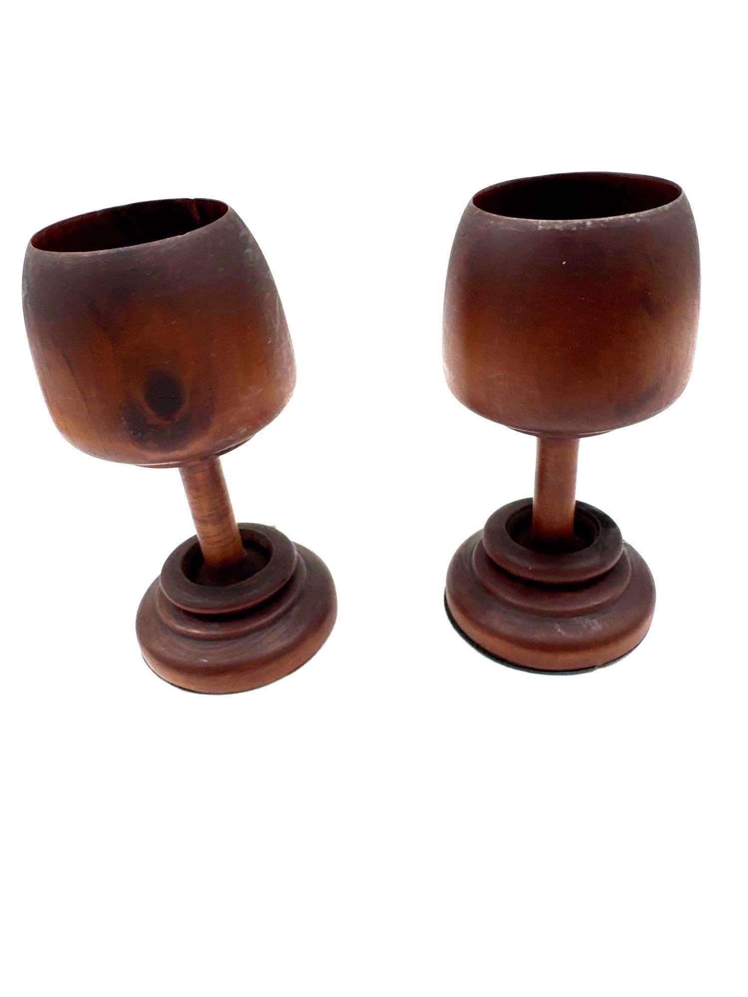Pair of Hand-Turned Wooden Goblets on Pedestal Bases: Rustic pair of goblet-style cups crafted from dark-stained wood, featuring a smooth finish and raised pedestal bases. Each piece displays subtle variations in tone and grain, highlighting their handcr