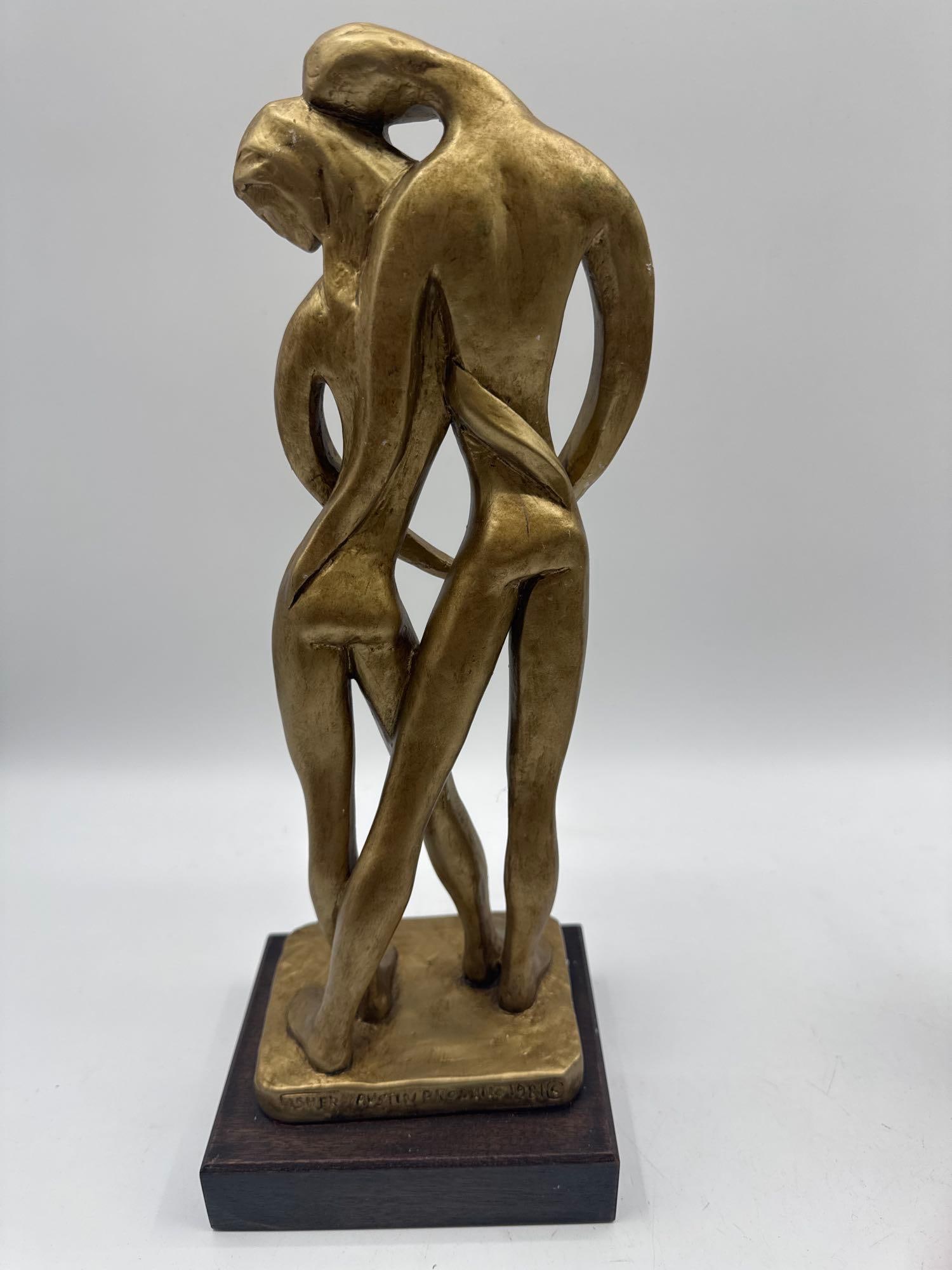 Embrace by Fisher, Austin Productions 1981: Stylized modern sculpture of a nude couple in a close embrace, rendered with flowing lines and elongated limbs, evoking intimacy and unity. Signed and dated by Fisher, produced by Austin Productions.