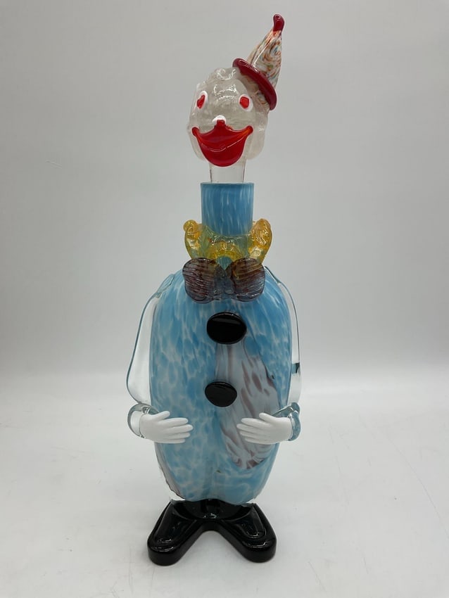 Murano Style Clown Figurine in Blue with Top Hat: Handcrafted whimsical clown figure featuring a blue speckled body, yellow bow tie, and sunglasses. Dimensions: H12in L6in W4in Medium: Blown glass.
