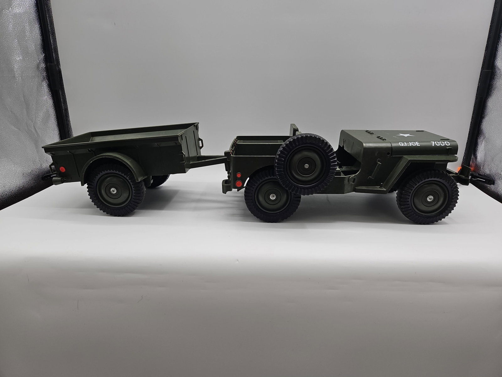 GI Joe Military Jeep with Trailer: Vintage GI Joe green military jeep with star insignia, opening hood, detailed interior, and detachable trailer. Includes small accessories inside hood compartment. Medium: Plastic and metal Trailer is