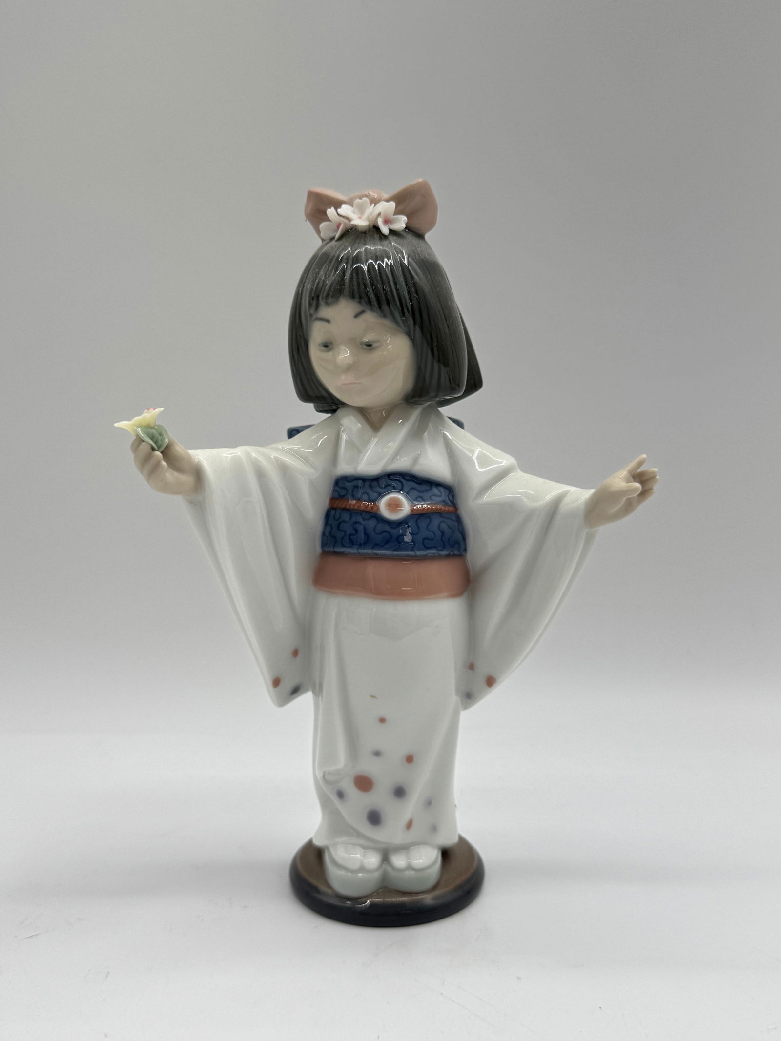 Lladro Figurine #5005 - Japanese Girl with Flower: Lladro figurine, #5005, depicting a Japanese girl in a kimono holding a flower. Marked on the bottom. Includes original box.