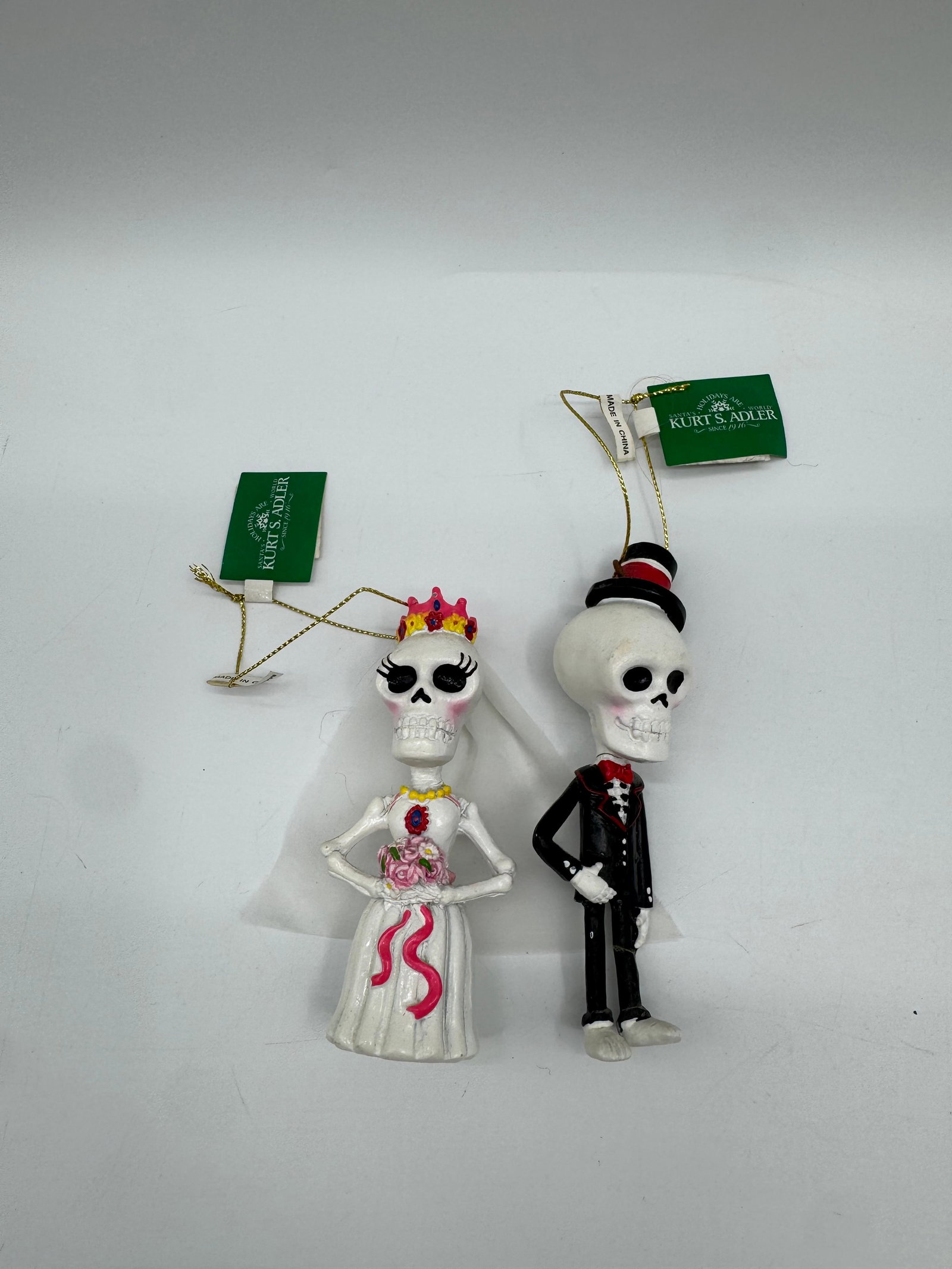 Kurt Adler Day of the Dead Bride & Groom Ornaments: Set of two Kurt Adler Day of the Dead ornaments. Includes a bride and groom skeleton figure, each with original tags and hanging loops. Bride features a crown and bouquet, groom features a top hat and