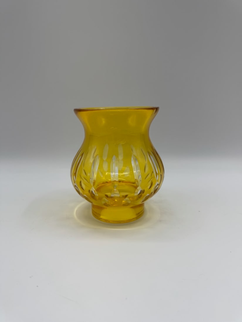 Amber Glass Vase with Etched Design: Amber-colored glass vase featuring an etched design. The vase has a bulbous shape with a flared rim and a pedestal base. The etched design consists of vertical lines and curved patterns. A decorative