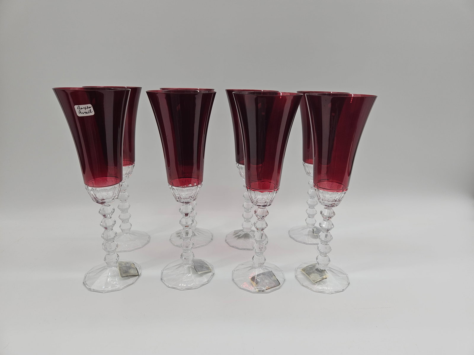 Set of Eight Mikasa Red Baron Champagne Flutes: Set of eight Mikasa 'Red Baron' champagne flutes. Each flute measures approximately 10 inches in height with a 3.25 inch diameter at the top. Features a red bowl and clear textured stem and ba