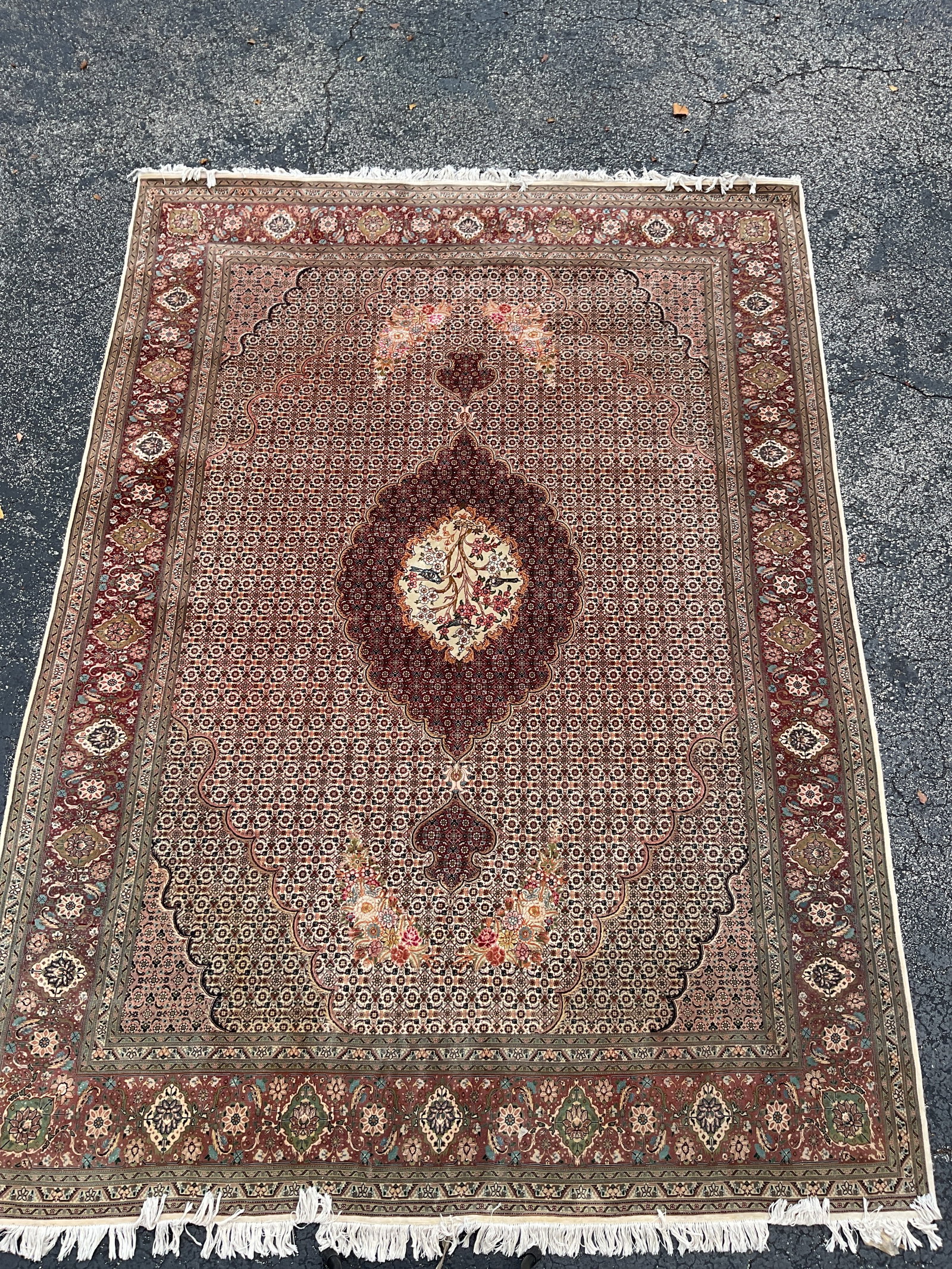 Handwoven Persian Rug with Medallion Center: A finely woven Persian rug featuring a central floral medallion design surrounded by intricate geometric and botanical motifs in shades of burgundy, cream, and olive. The detailed border pattern and t