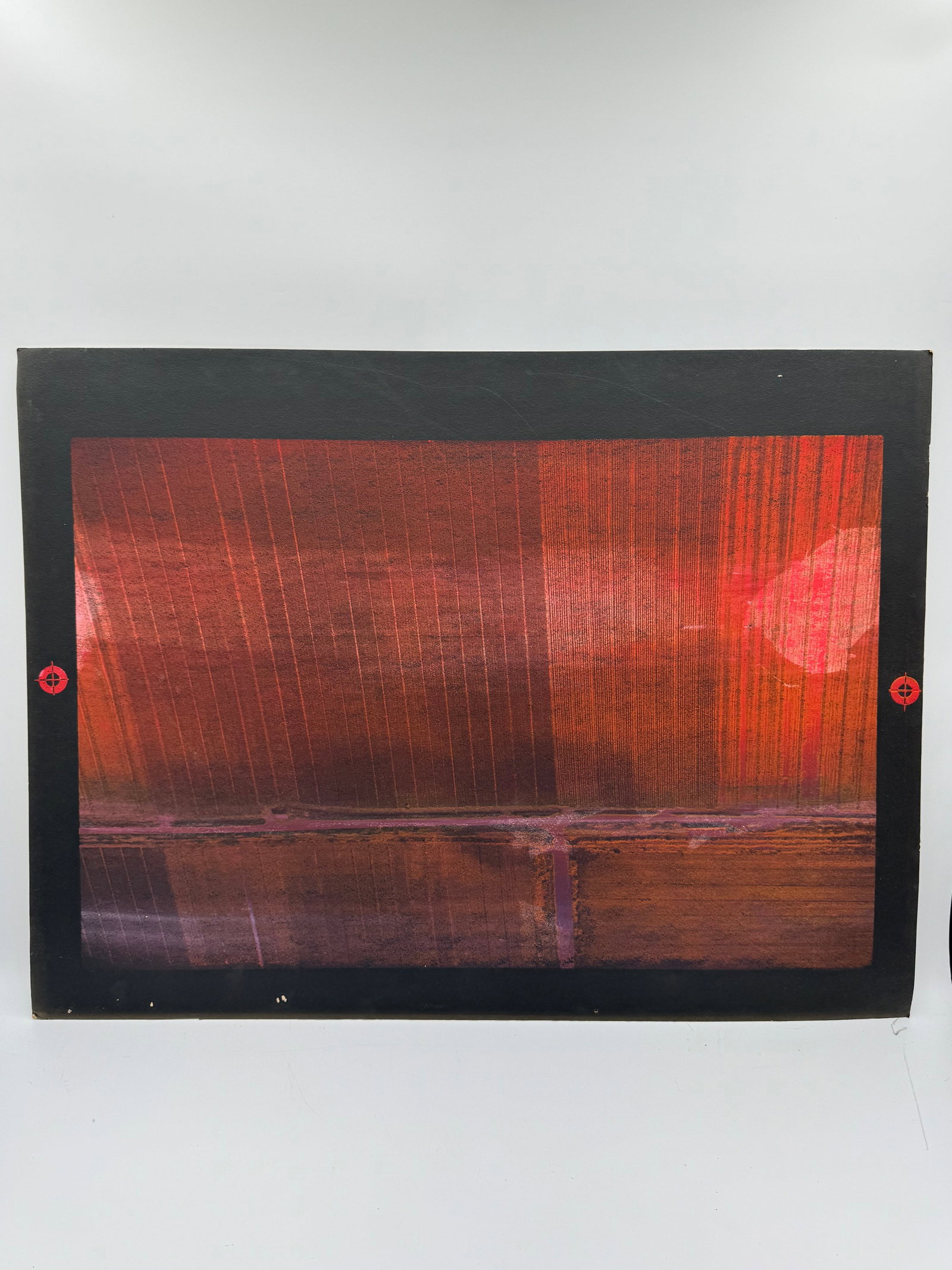 Abstract print: Abstract print featuring vertical lines and a horizontal band, predominantly in shades of red and brown. The artwork is framed with a black border and red accents. Dimensions: 40 x 30 inches.