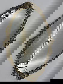 Ornate Oval Gilt Filigree Mirror Tray: Vintage oval vanity or perfume mirror tray with intricate floral filigree brass frame and black velvet backing.Medium: Mirror, brass, velvetDimensions: H:25in L:16in W:2in