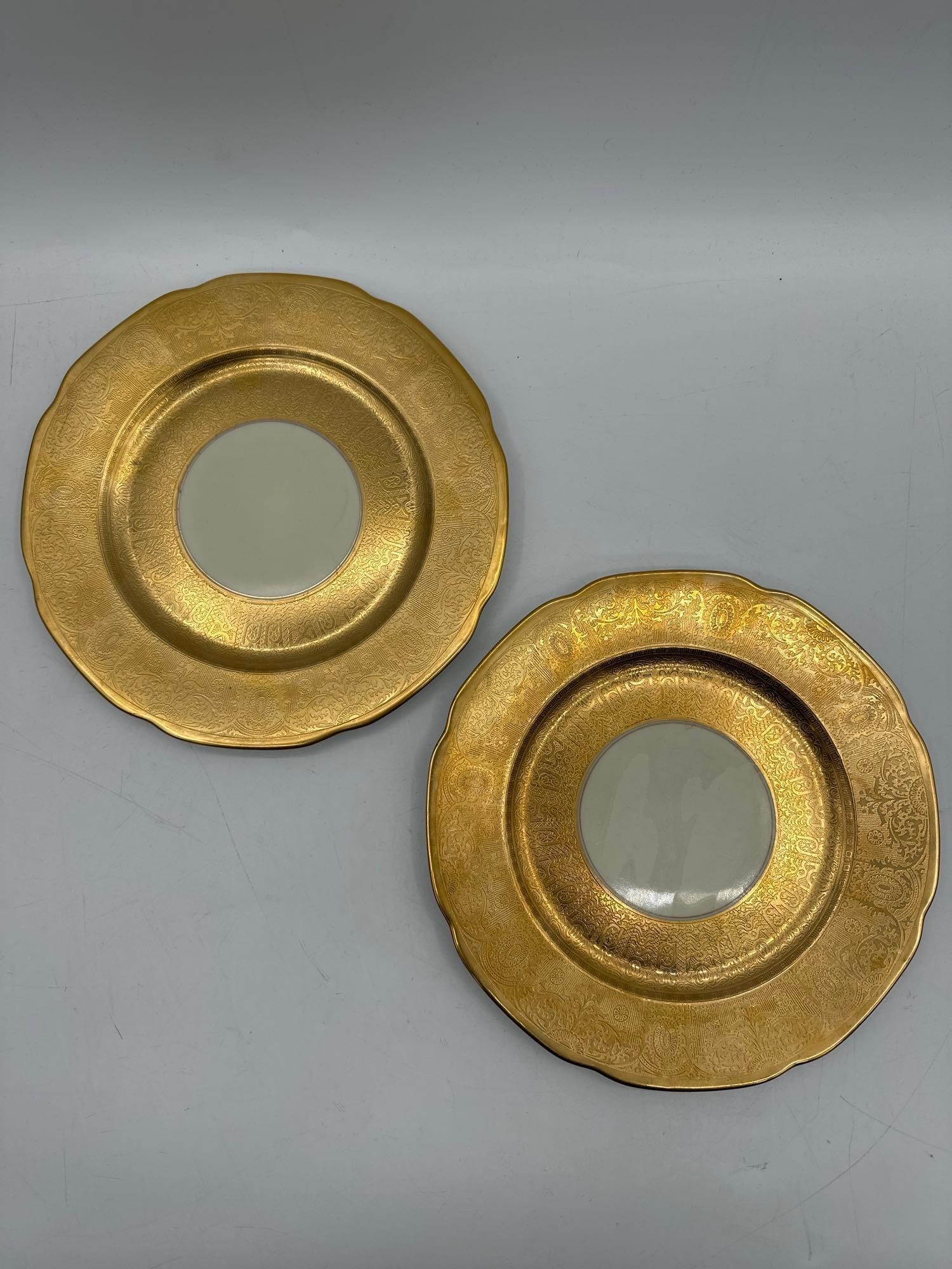 Claremont Gold tone Encrusted Dinner Plates Set of 2: Pair of porcelain dinner plates by Claremont featuring a central ivory well surrounded by ornate gold tone encrusted rims with floral and scroll patternsMedium: Porcelain with gold tone detailing