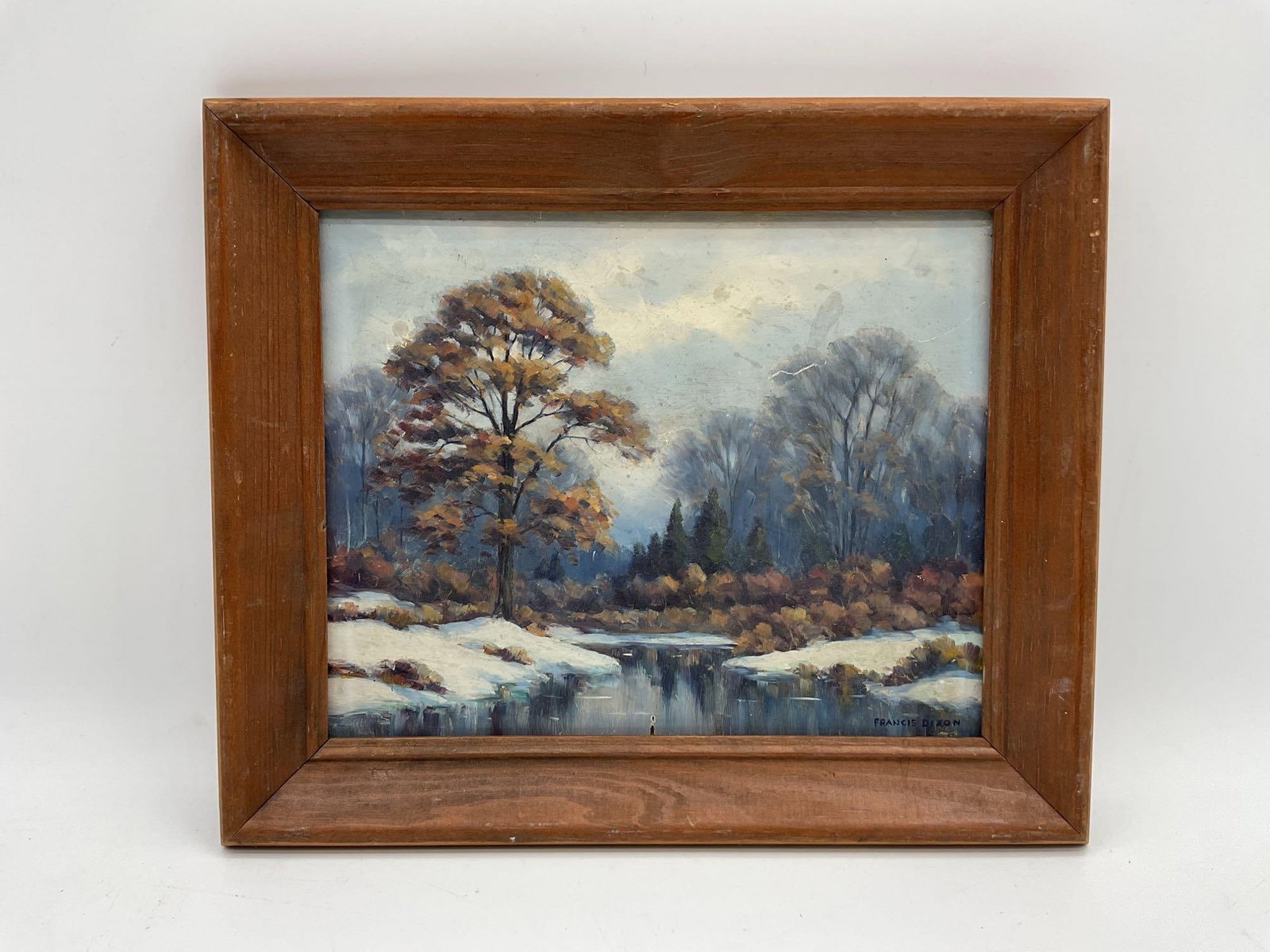 Francis Dixon, Winter River Landscape, Oil on Canvas: This is a framed oil painting by the American artist Francis Stillwell Dixon (1879–1967). It depicts a tranquil winter landscape with a snow-covered bank leading down to a body of water. A promi