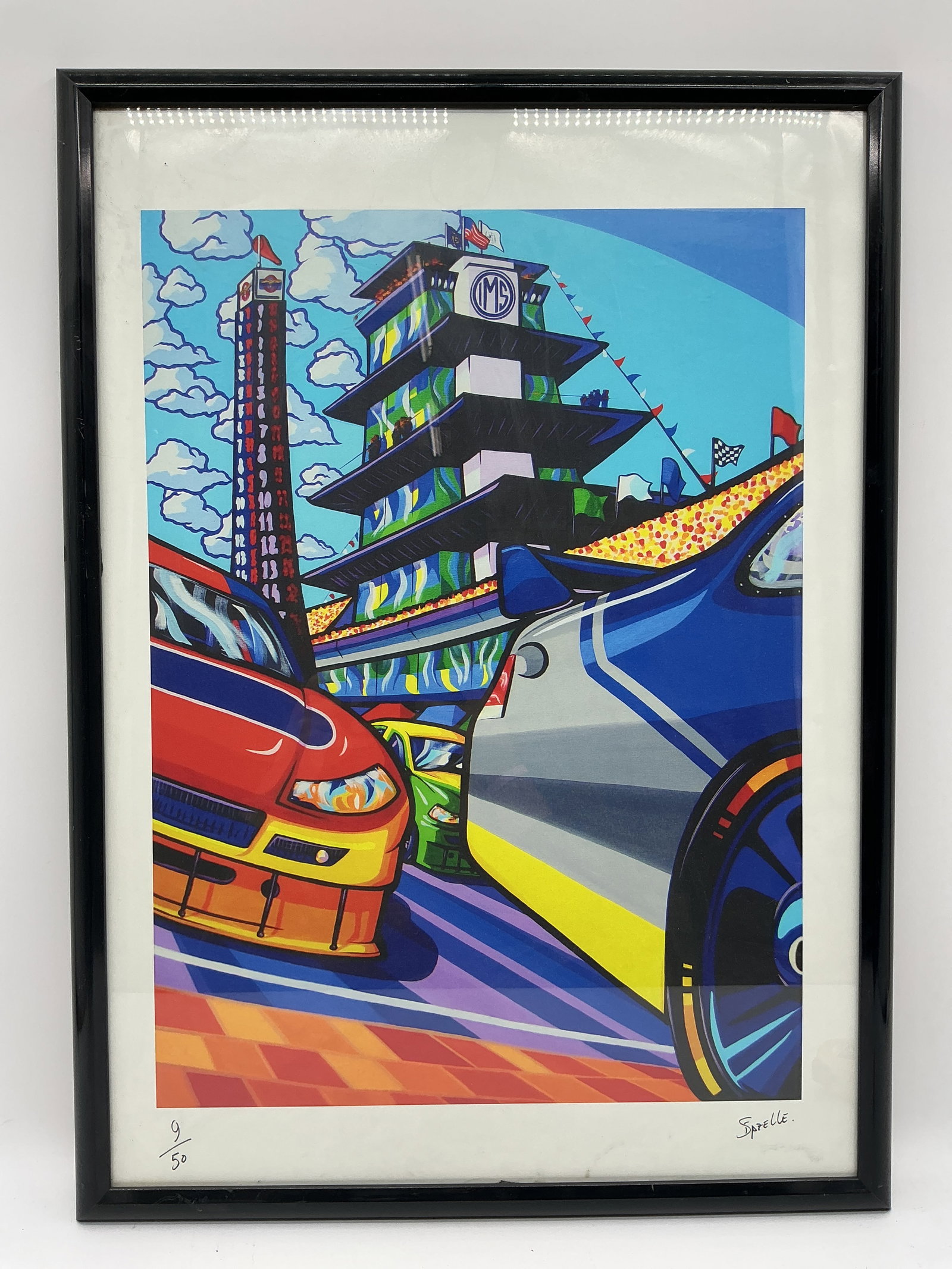 Spezelle Indianapolis Motor Speedway Print, Signed 9/50: Framed and matted print by Spezelle depicting the Indianapolis Motor Speedway. Signed in the lower right and numbered 9/50 in the lower left. Dimensions: 29 x 21 inches.