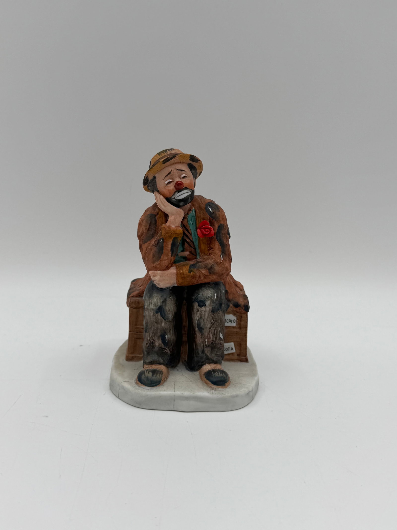 Emmett Kelly Jr. Figurine: Emmett Kelly Jr. figurine, "The Original Buratt Kelly" from the Clowns Collection. The figurine depicts a sad clown sitting on a suitcase. Marked on the base. Measures approximately 5 x 3 x 