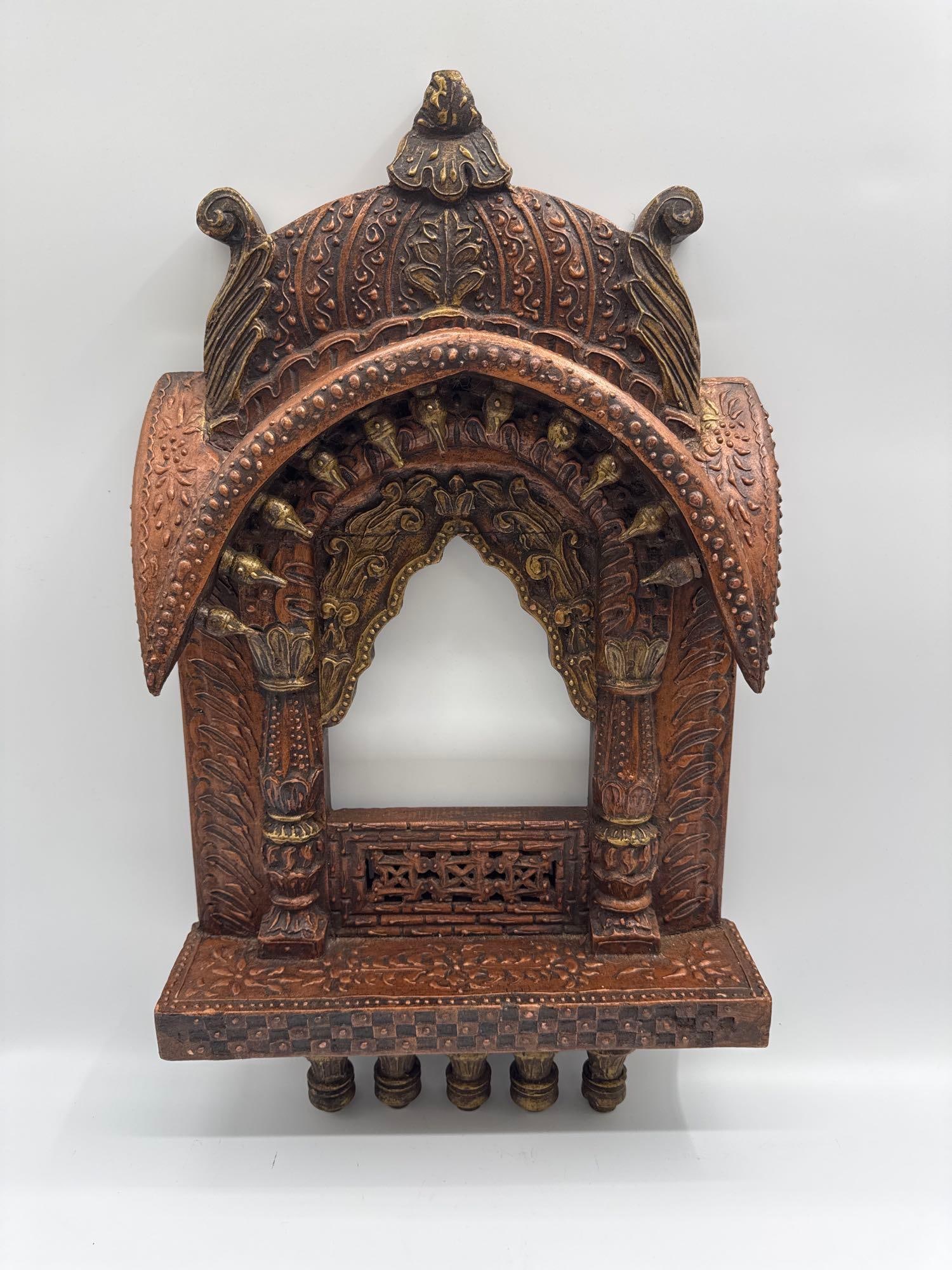 Hand-Carved Wooden Temple Niche: Ornately hand-carved wooden temple niche or wall shrine with intricate floral and architectural motifs. Features an arched alcove framed by decorative columns and a domed top, highlighted with gold-to
