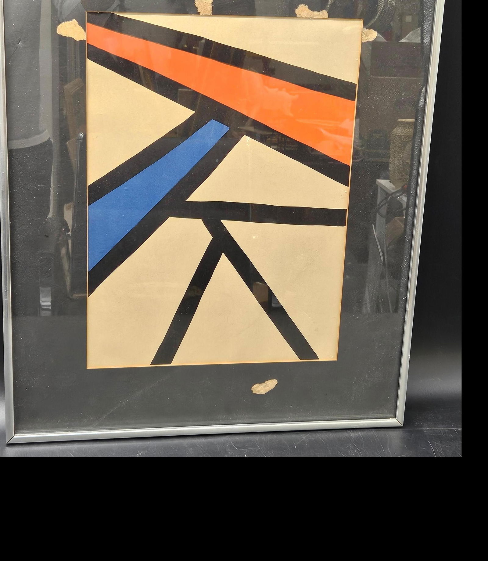Alexander Calder Derriere Le Mirror: A framed abstract geometric artwork featuring intersecting black lines with bold red and blue accents on a beige background. The composition suggests an influence of Constructivism or De Stijl, charac