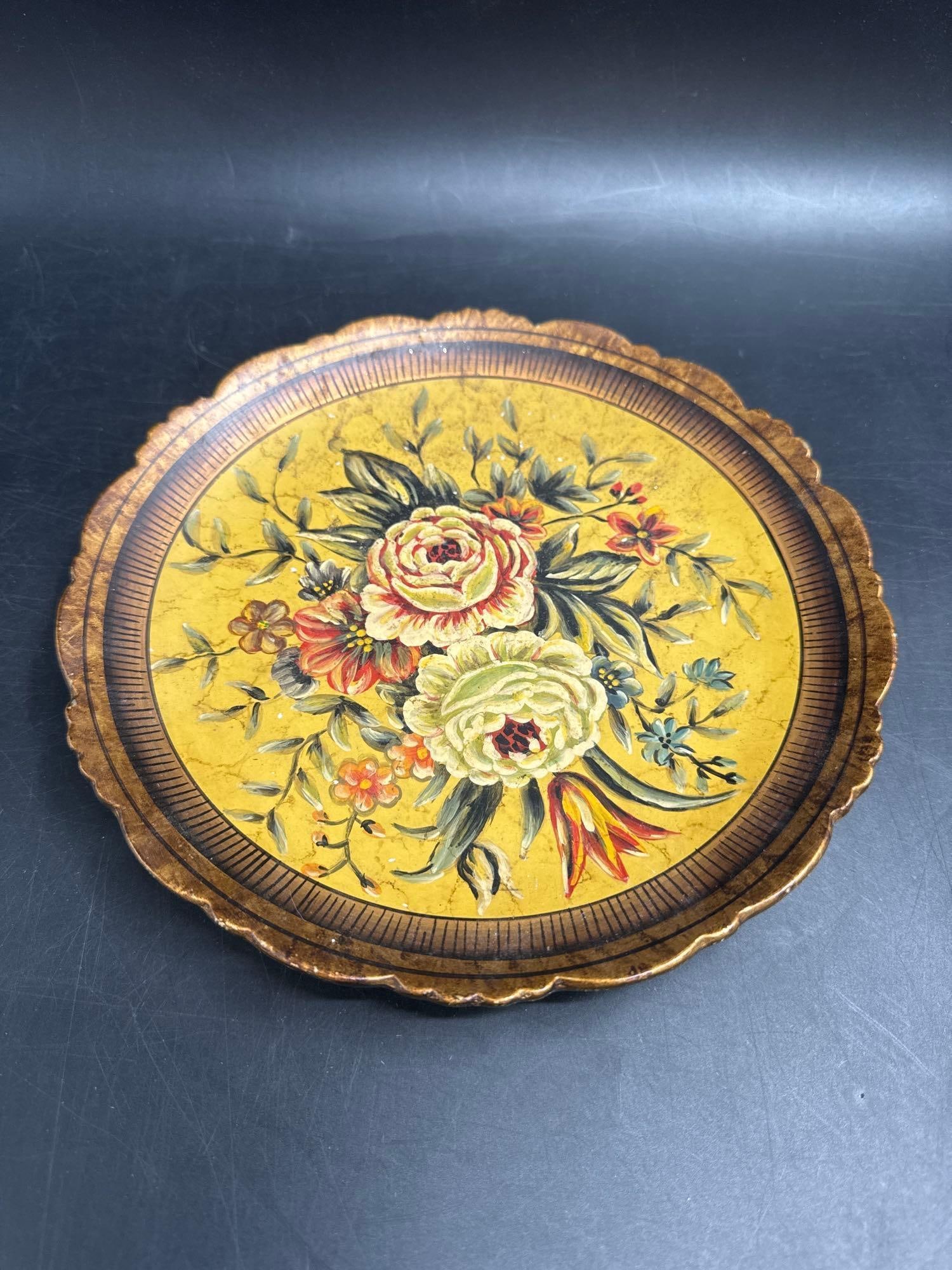 Vintage Italian Florentine Gilt Wood Floral Tray: Round hand-painted Florentine tray featuring a central bouquet of roses and flowers in red, cream, and green against a golden yellow background. The scalloped edge is accented with gilt detailing, giv