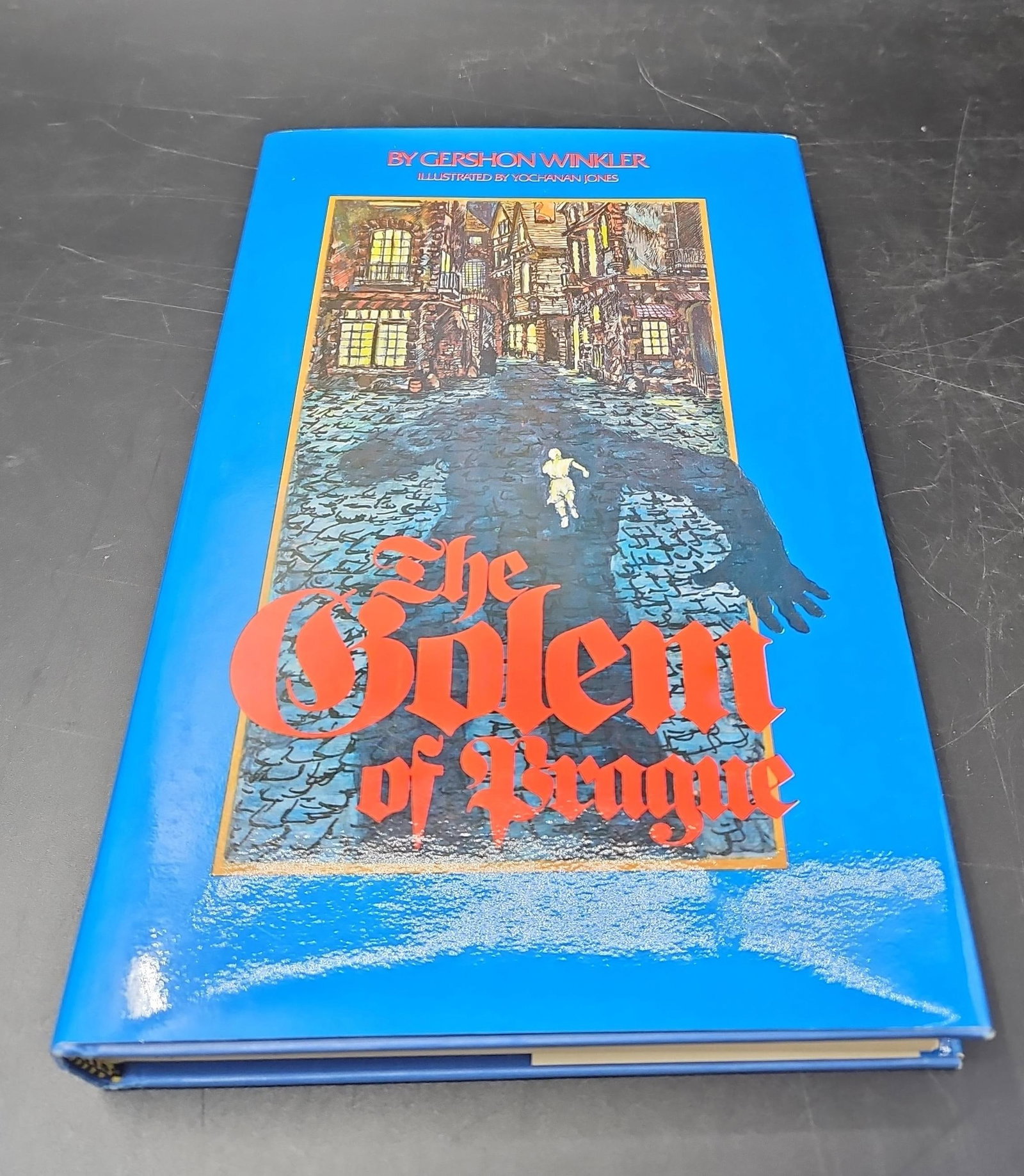 The Golem of Prague by Gershon Winkler: Illustrated edition of the Jewish folktale The Golem of Prague, written by Gershon Winkler and illustrated by Yochanan Jones. Hardcover with dust jacket, featuring vivid cover art depicting the l
