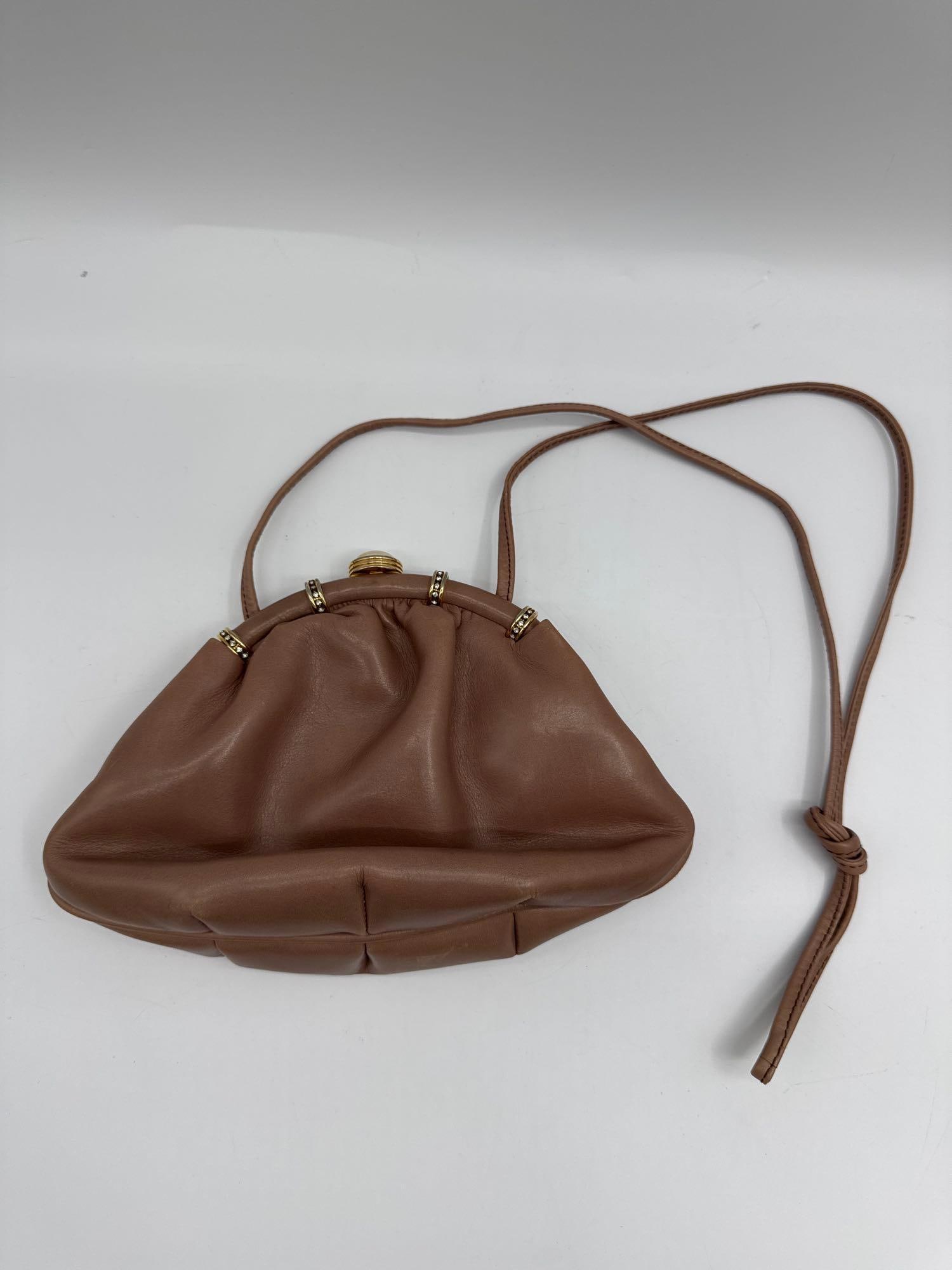 Susan Gail Leather Shoulder Bag: Vintage Susan Gail handbag made in Spain, crafted from genuine brown leather. Features a structured gathered design with gold-tone hardware, pearl clasp closure, and a long leather strap. Interior lin