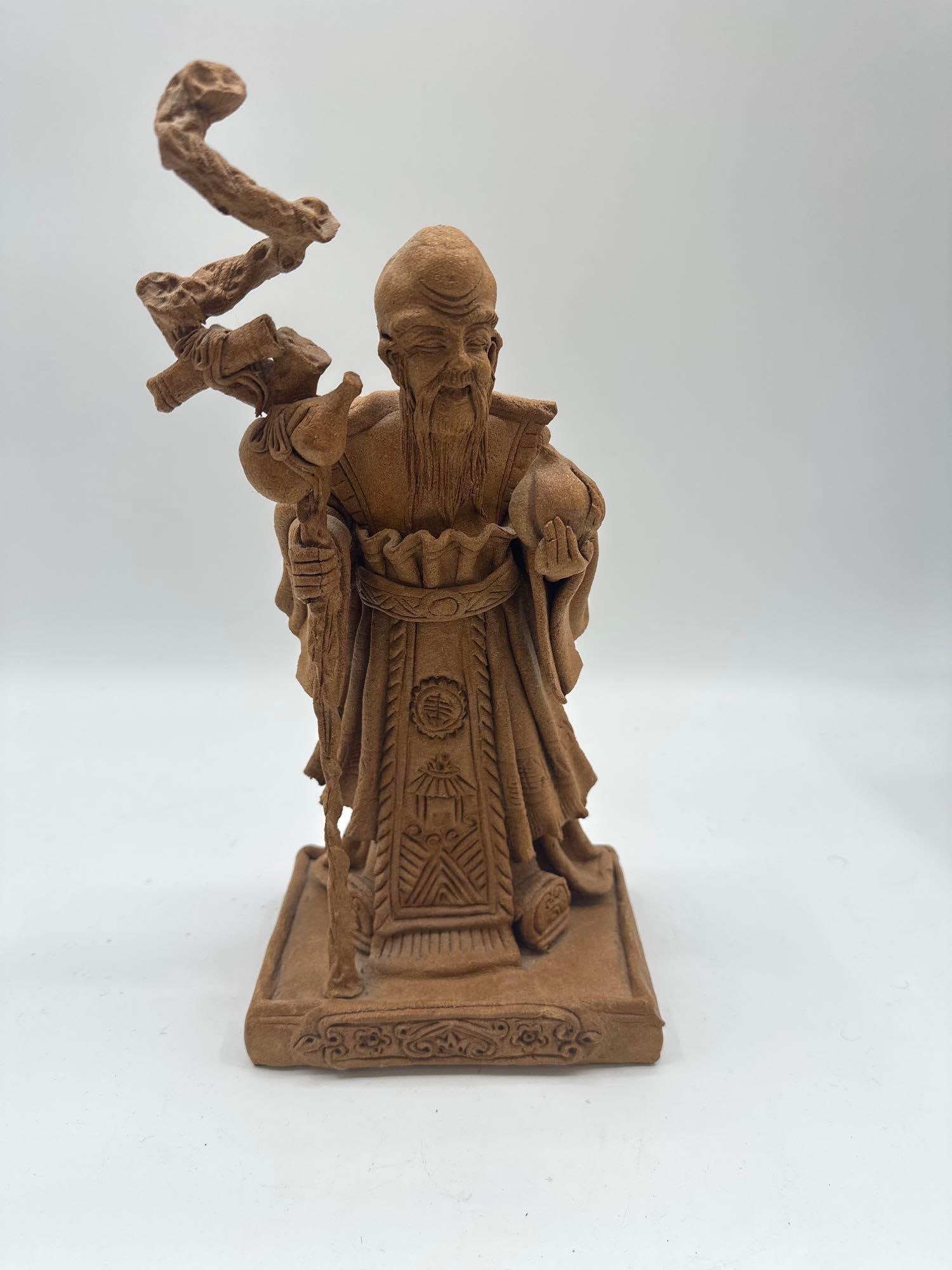 Shou Xing – Chinese God of Longevity Figurine: Detailed figurine of Shou Xing (Shou Lao), the Taoist deity of longevity, depicted with a high domed forehead, long beard, and traditional robe. He holds a gnarled staff with a scroll or peach and a p